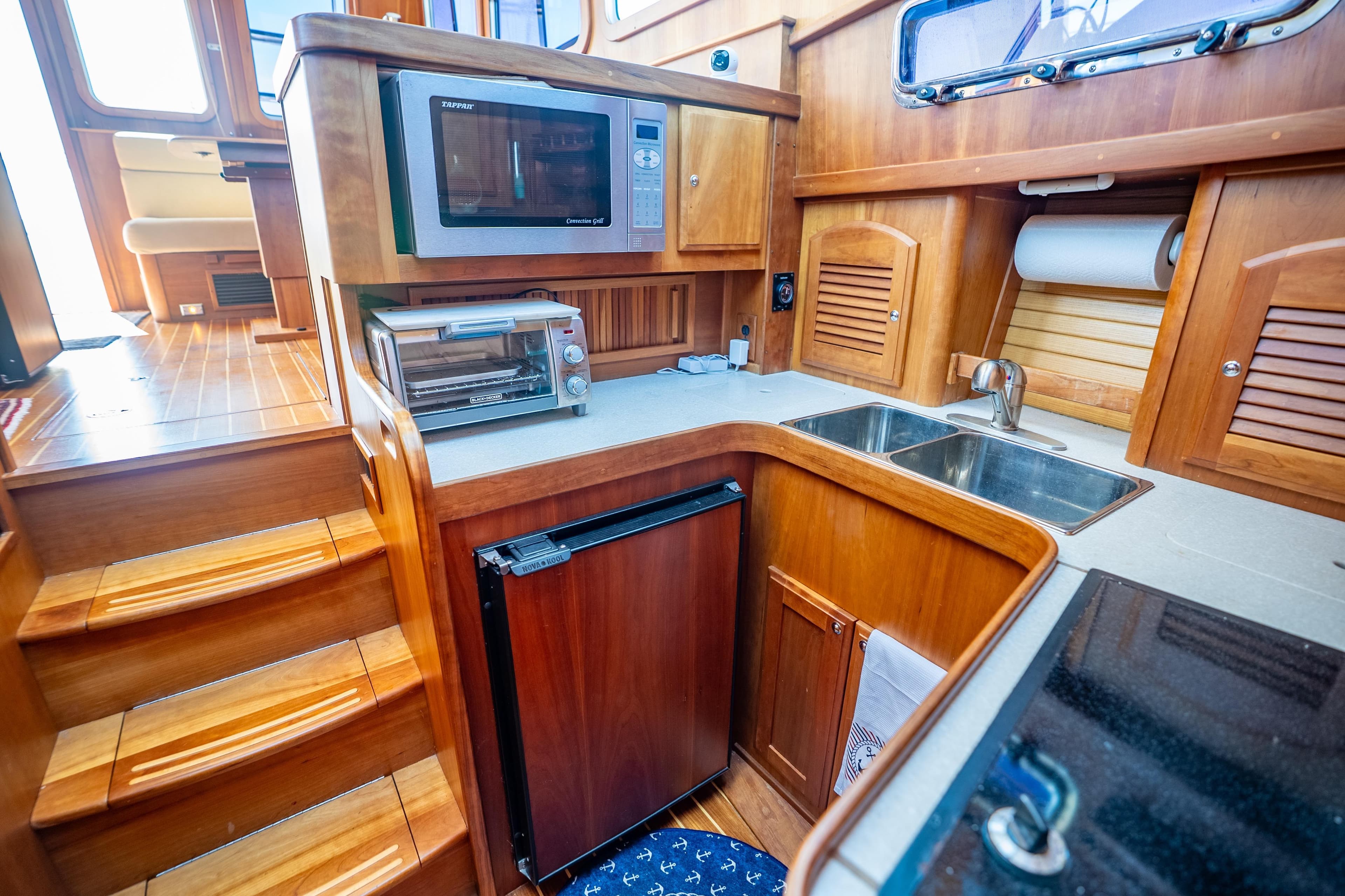 2006 Sabreline 36 Fly yacht kitchen with microwave, toaster oven, and wooden cabinetry.