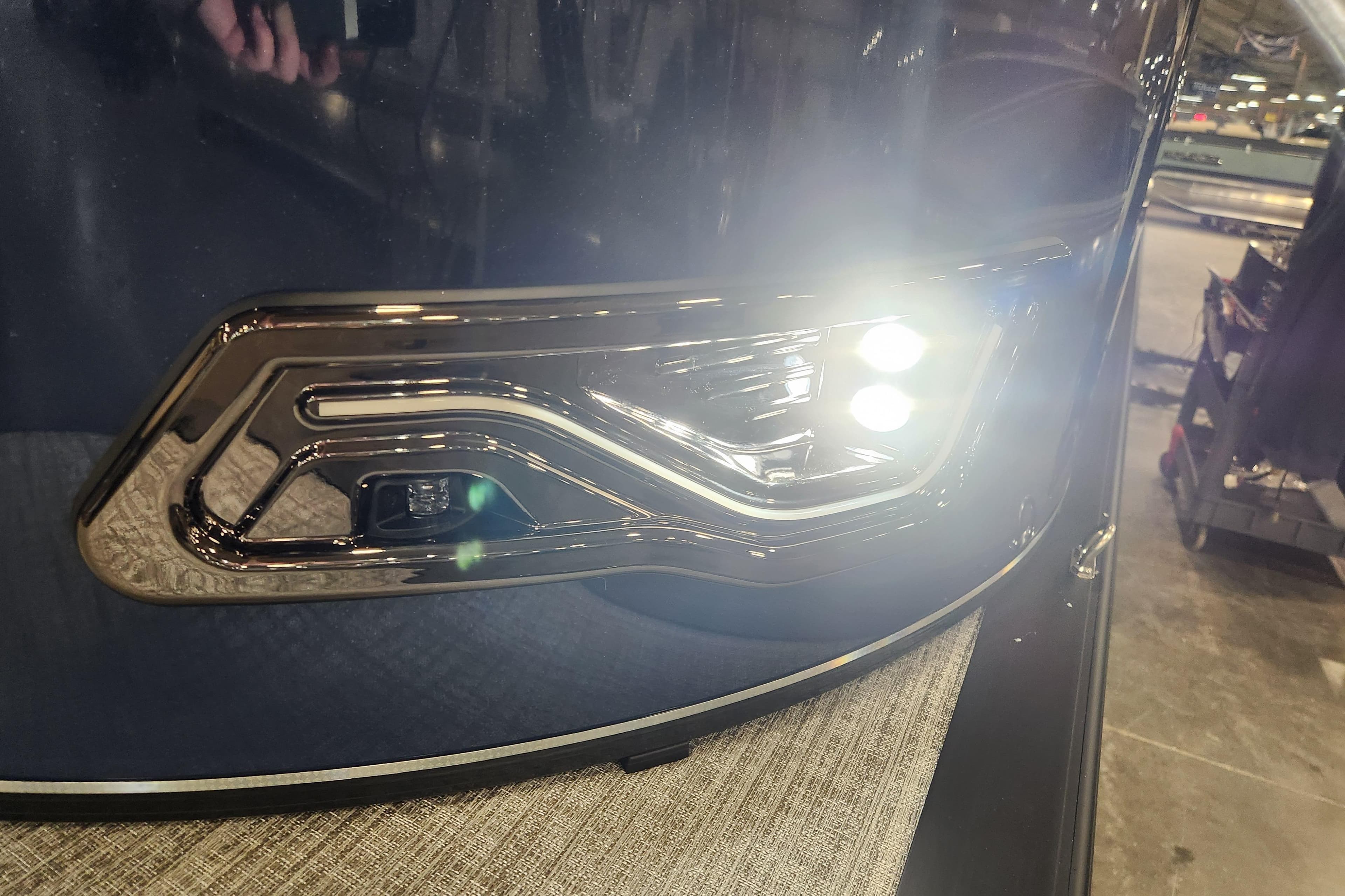 2026 Tahoe Pontoon 23 LTZ Rear Bench with illuminated LED lights in a showroom.