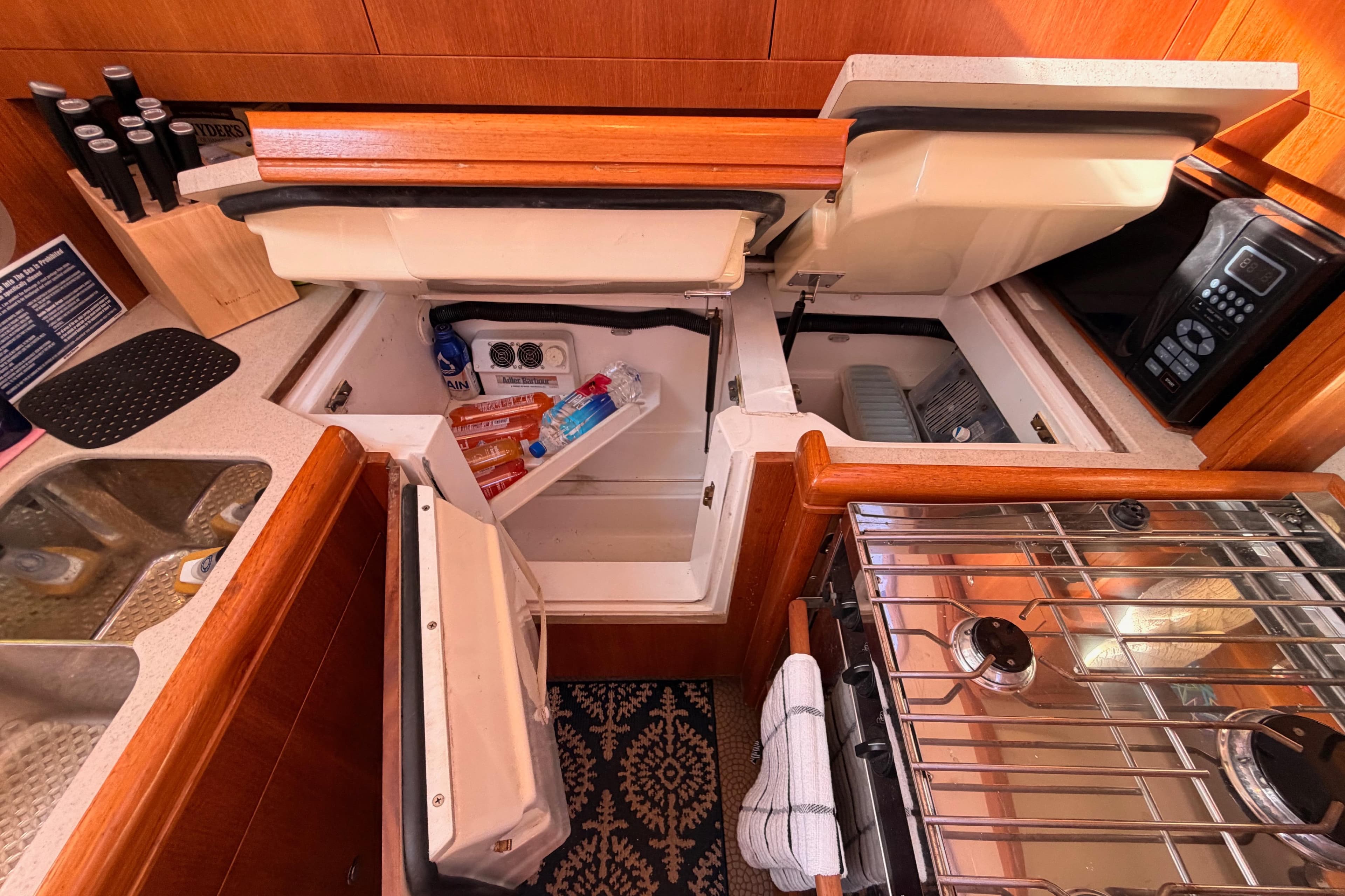 2005 Hunter Passage 456 yacht kitchen with open fridge, stove, and sink.