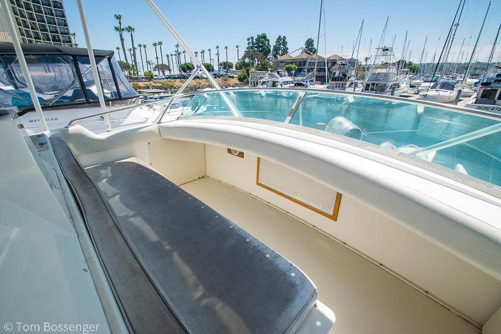 1986 Bertram 42 Convertible yacht interior with marina view, featuring spacious seating area.