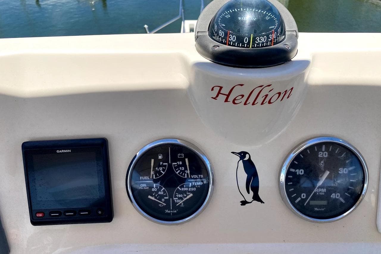 Dashboard of 2005 Mainship 34 Trawler with compass, gauges, and Garmin display.