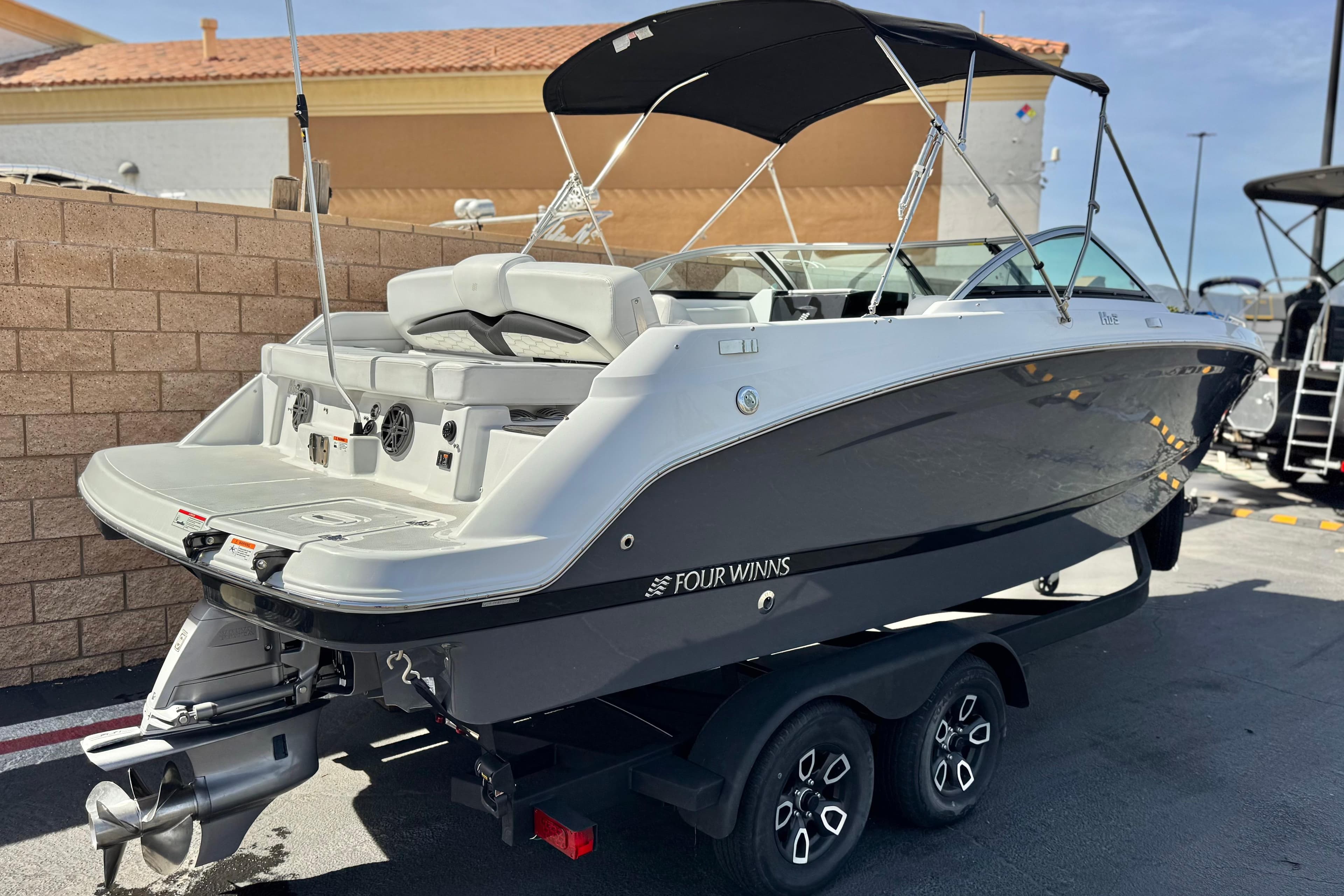 2023 Four Winns HD3 boat on trailer, sleek design, parked outdoors.