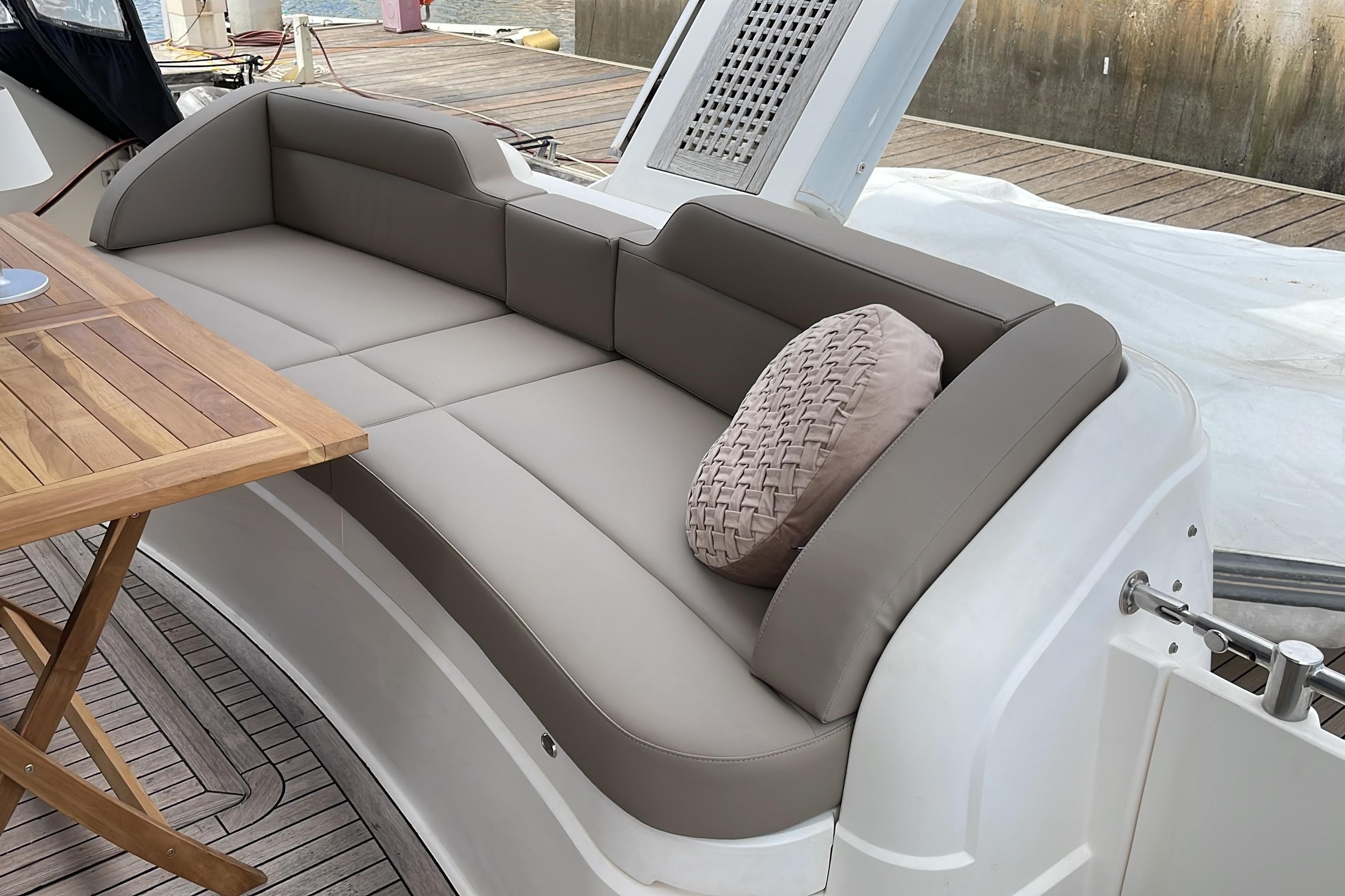Luxury seating area on 2001 Fairline Squadron 58 yacht with wooden table and cushion.