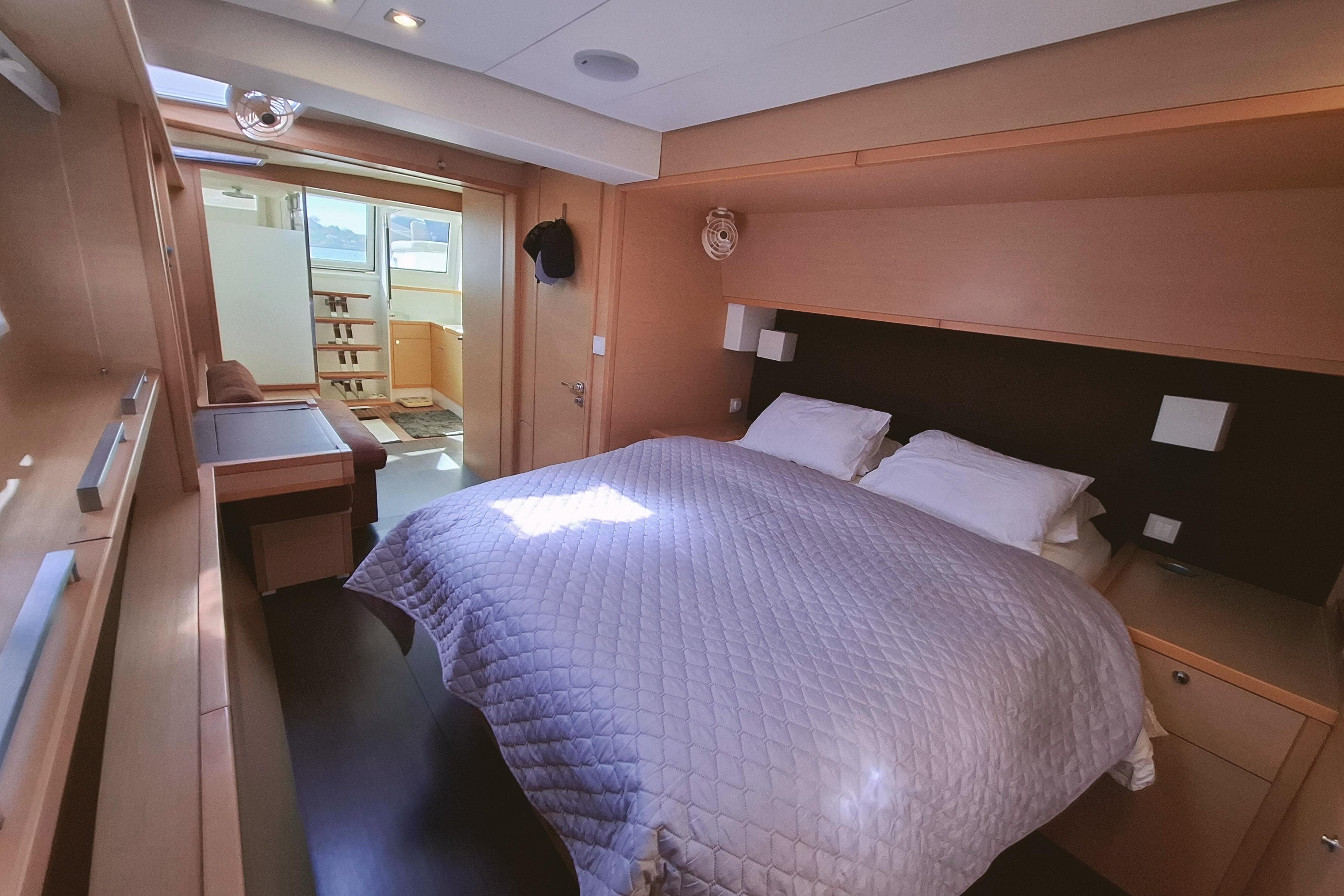 Luxurious bedroom interior of 2015 Lagoon 620 yacht with cozy bedding and modern design.