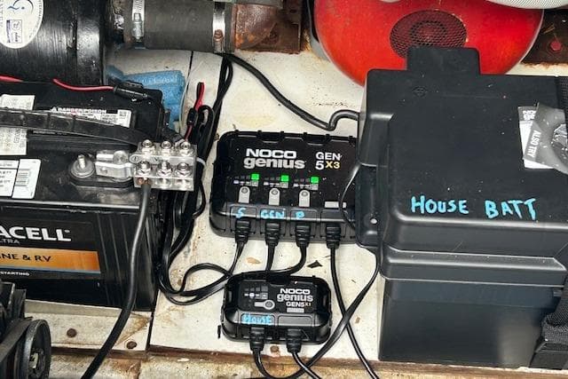 Battery setup on 1987 Somerset Houseboat with NOCO Genius charger and labeled house battery.