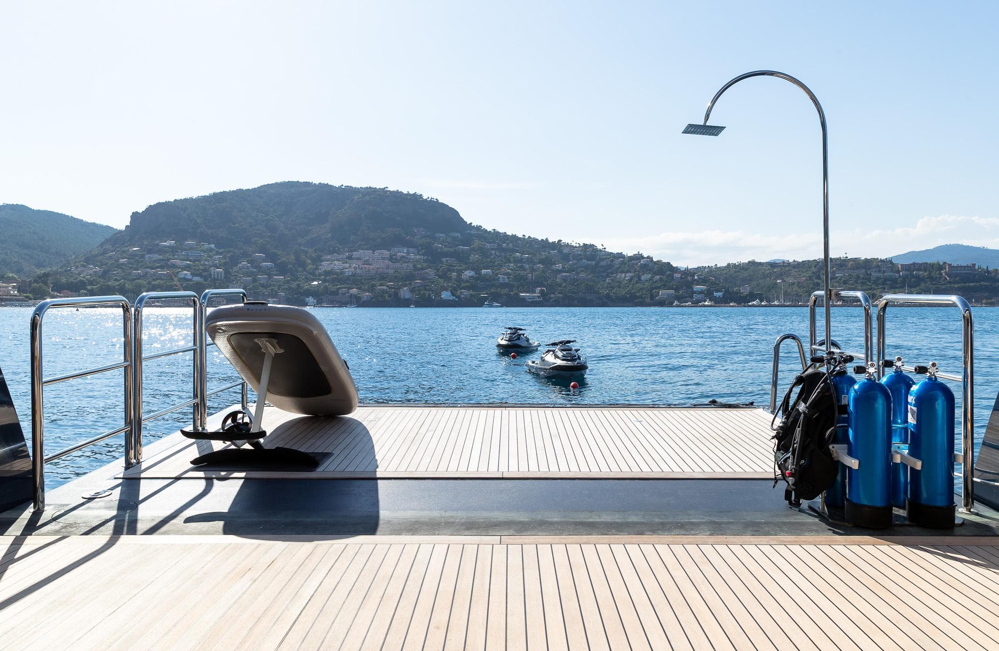 Luxurious Benetti 60 yacht deck with diving gear, overlooking serene coastal waters, 2011 model.