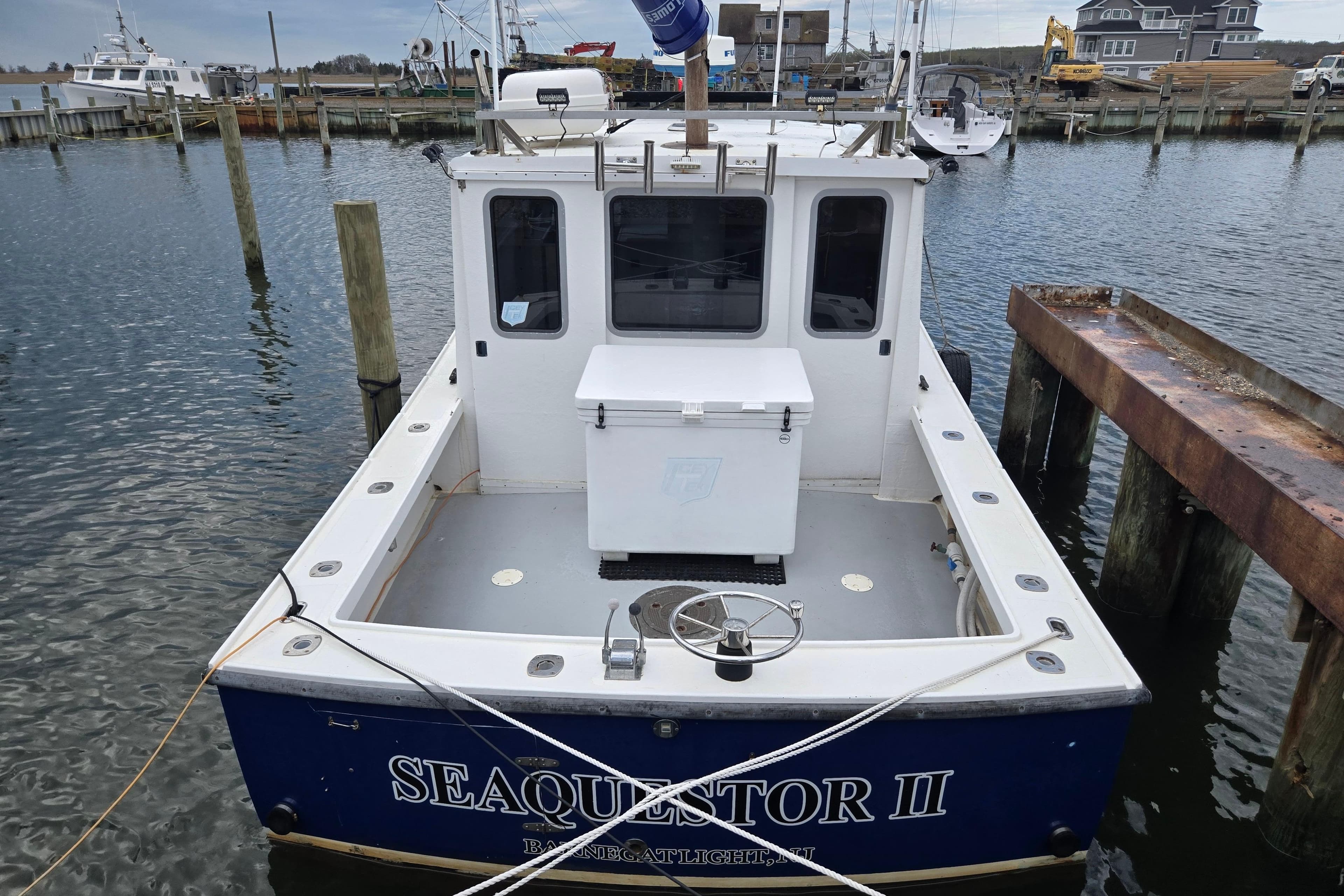 1977 JC 31 Casco Bay boat docked at marina, rear view with open deck.