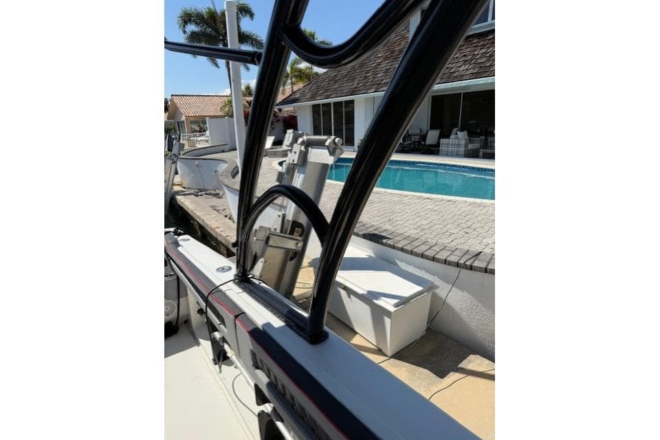 1996 Powerplay Powerboats 33 Sportfish near poolside, showcasing sleek design and sturdy structure.