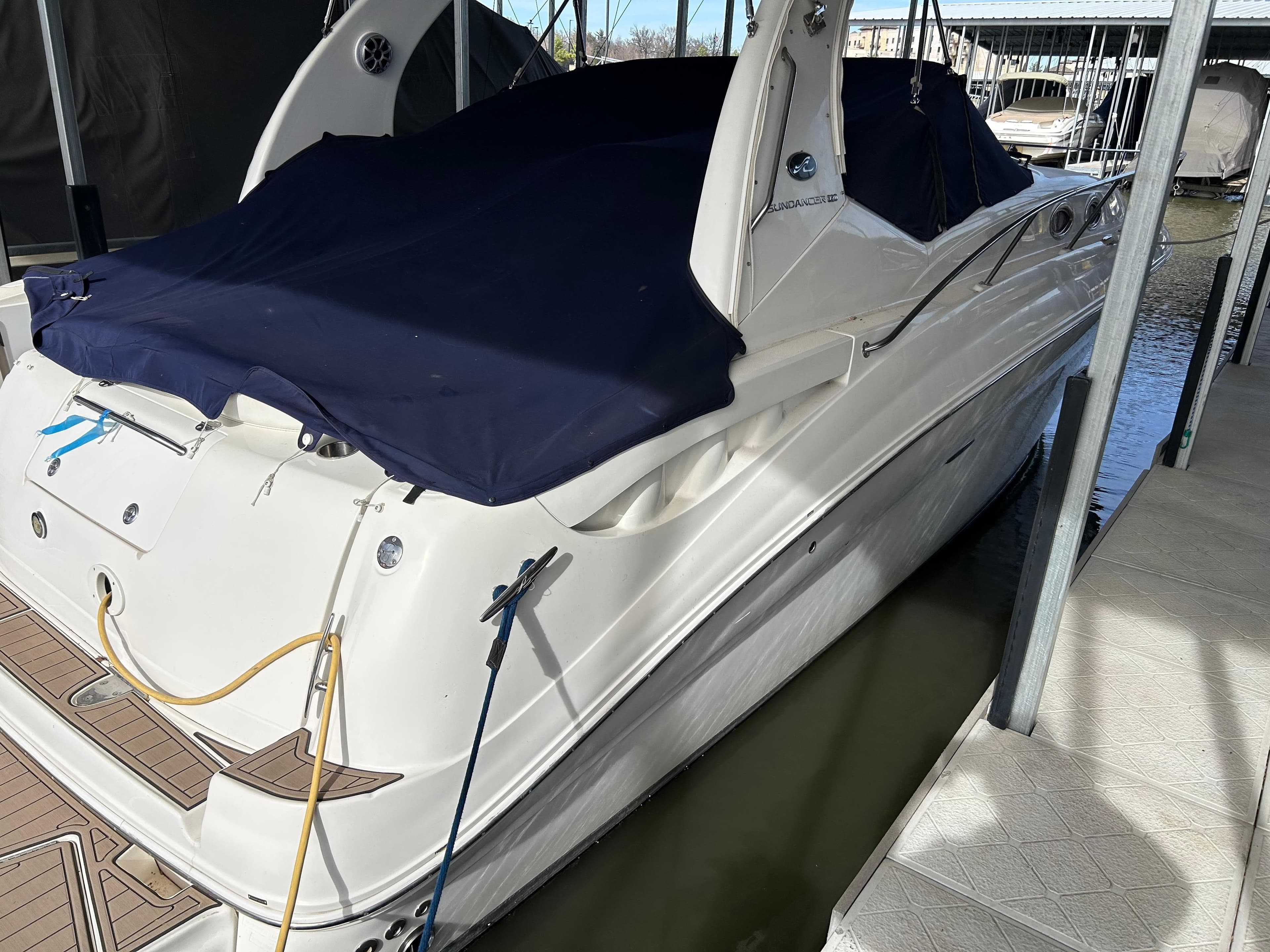 2006 Sea Ray 320 Sundancer docked, covered with a navy blue tarp.