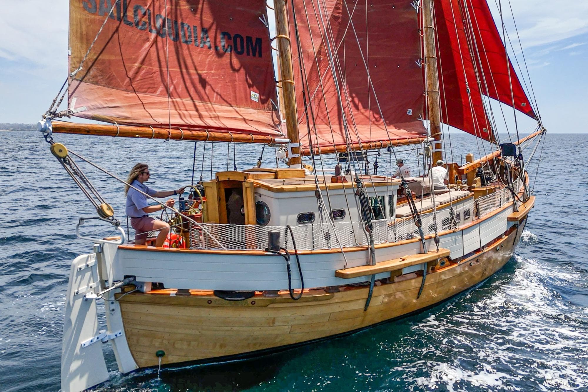 1938 Norwegian Double Ended Ketch sailing on open sea with red sails.