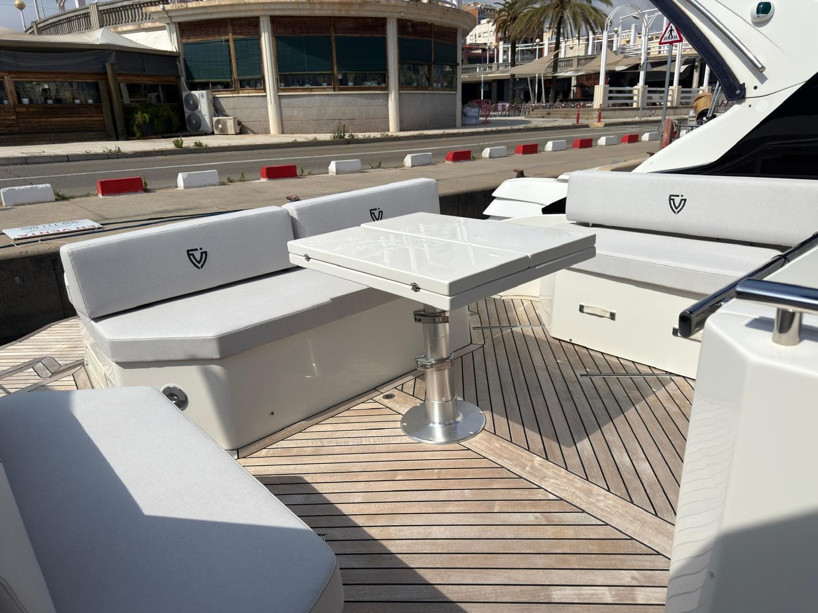 Luxury seating area on 2024 FIM 340 yacht with sleek white cushions and table.