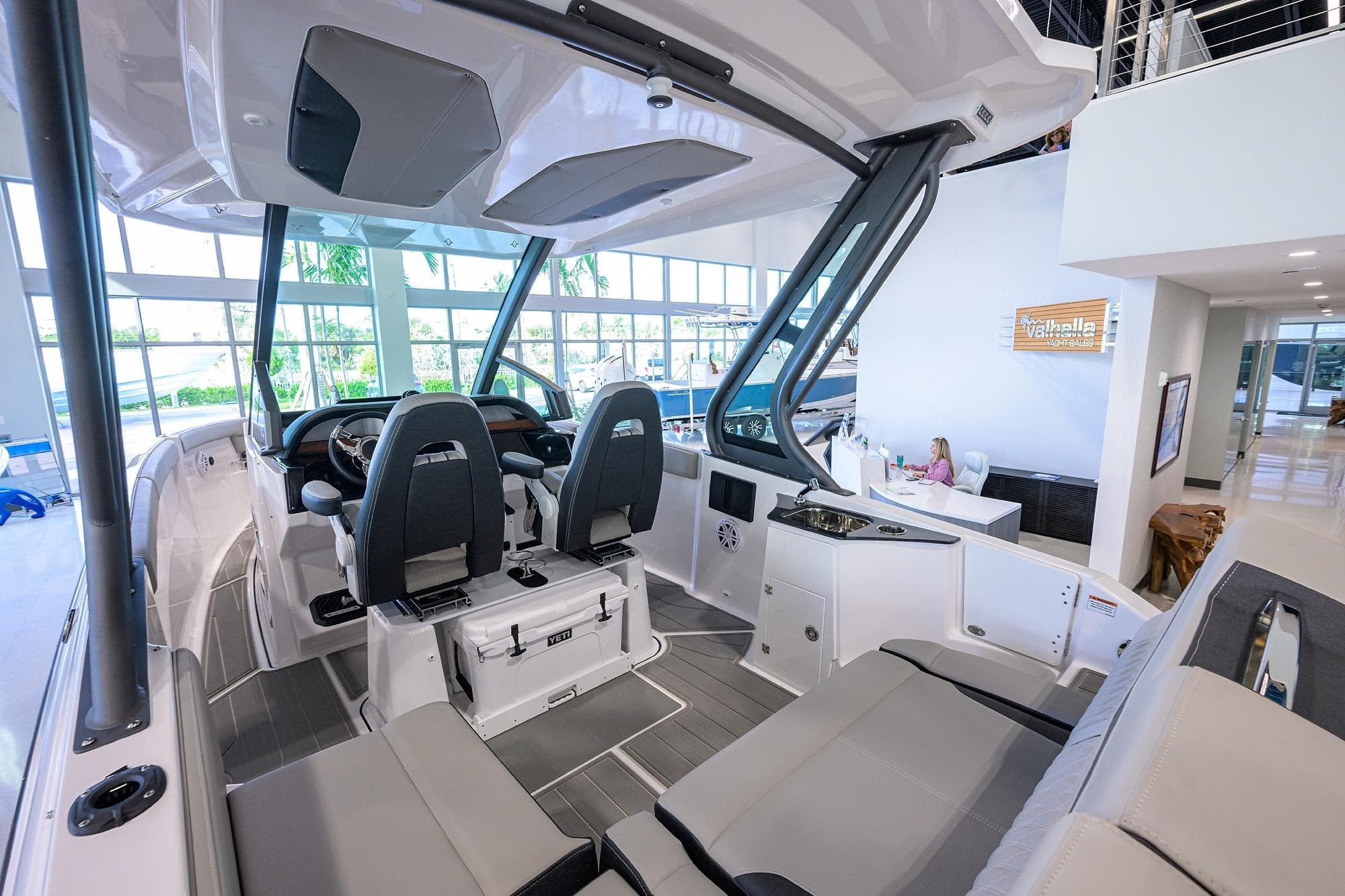 2026 Monterey Elite 25 OB boat interior with modern seating and helm in showroom.
