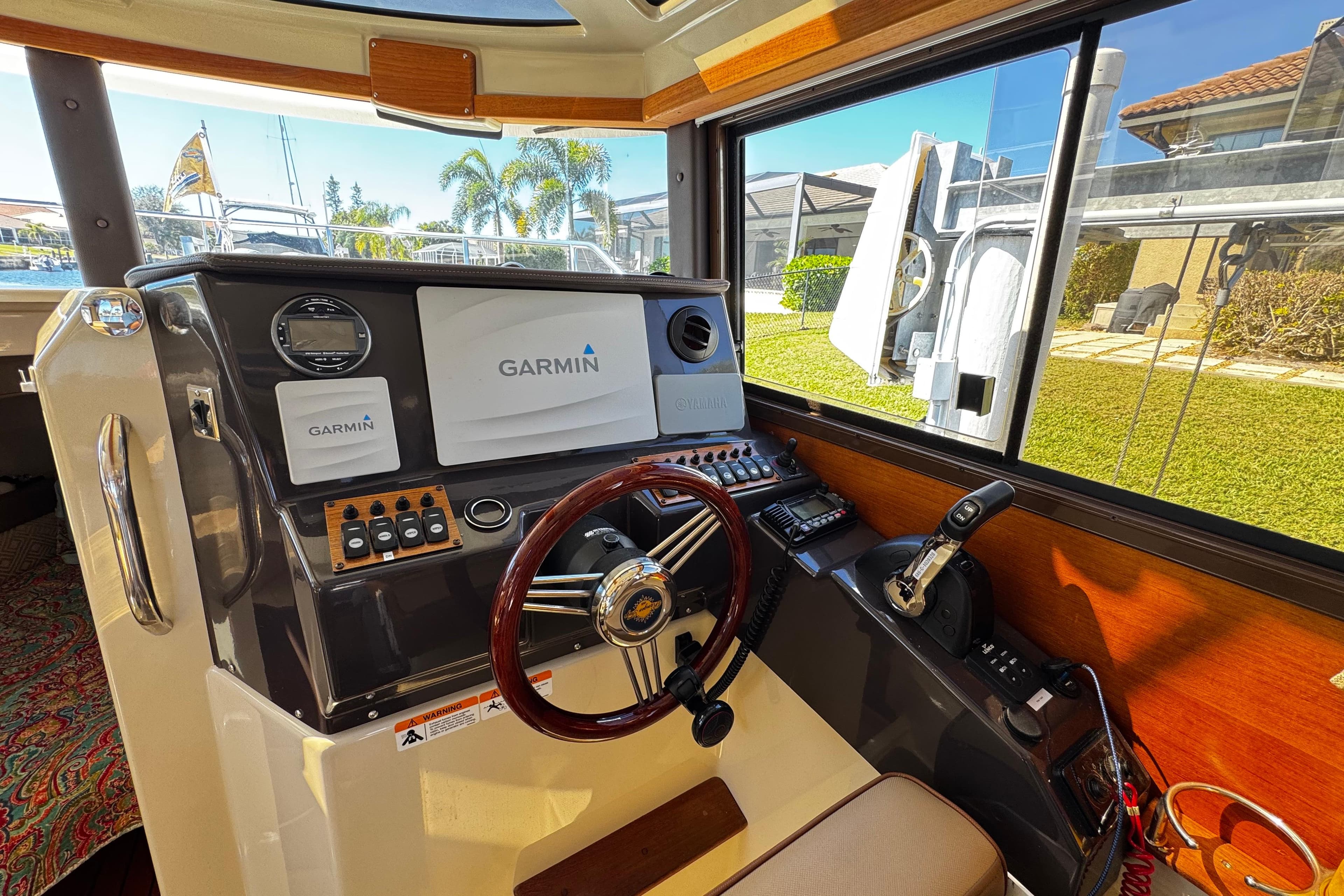 2020 Ranger Tugs R-25 helm with Garmin navigation system and wooden steering wheel.