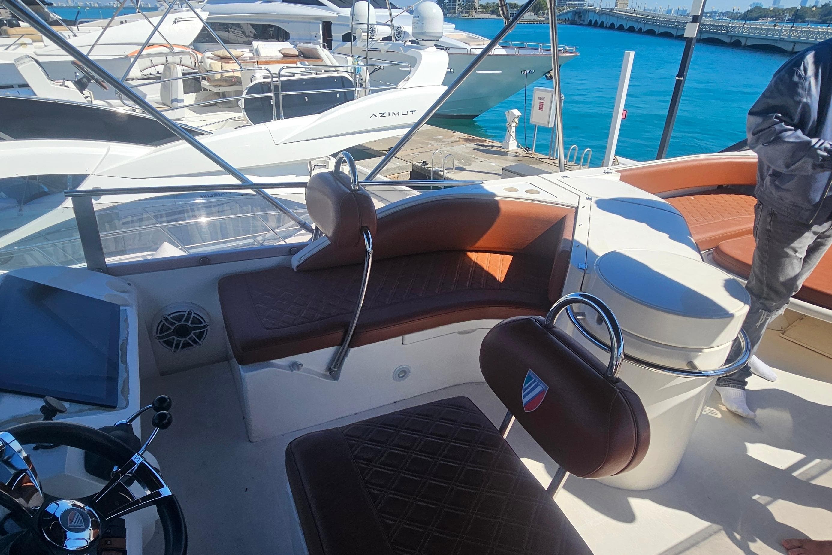 Luxurious 2006 Fairline 50 yacht interior with leather seating and steering wheel, docked at marina.