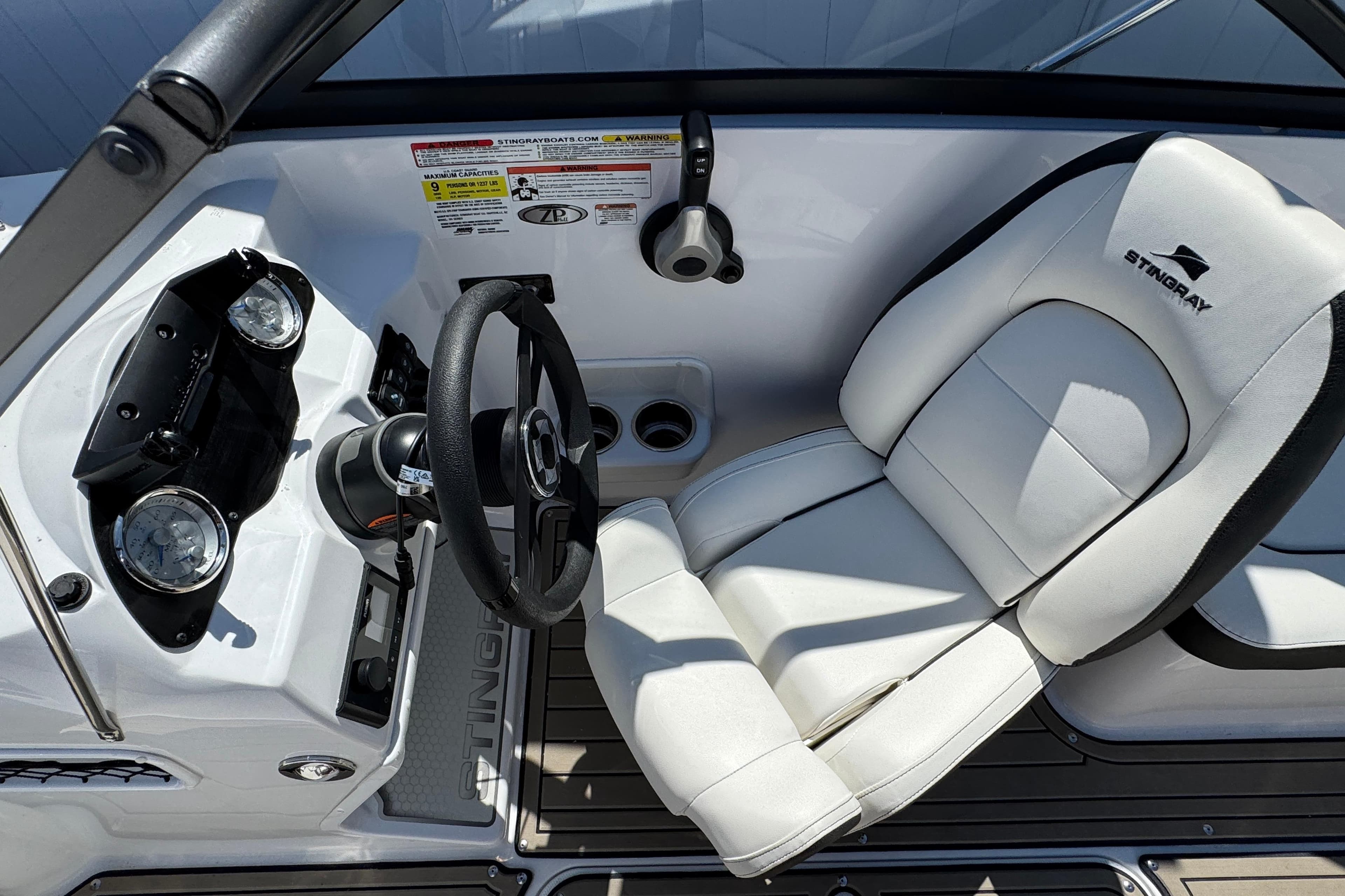 2025 Stingray 191 DC boat interior with steering wheel and white captain's seat.