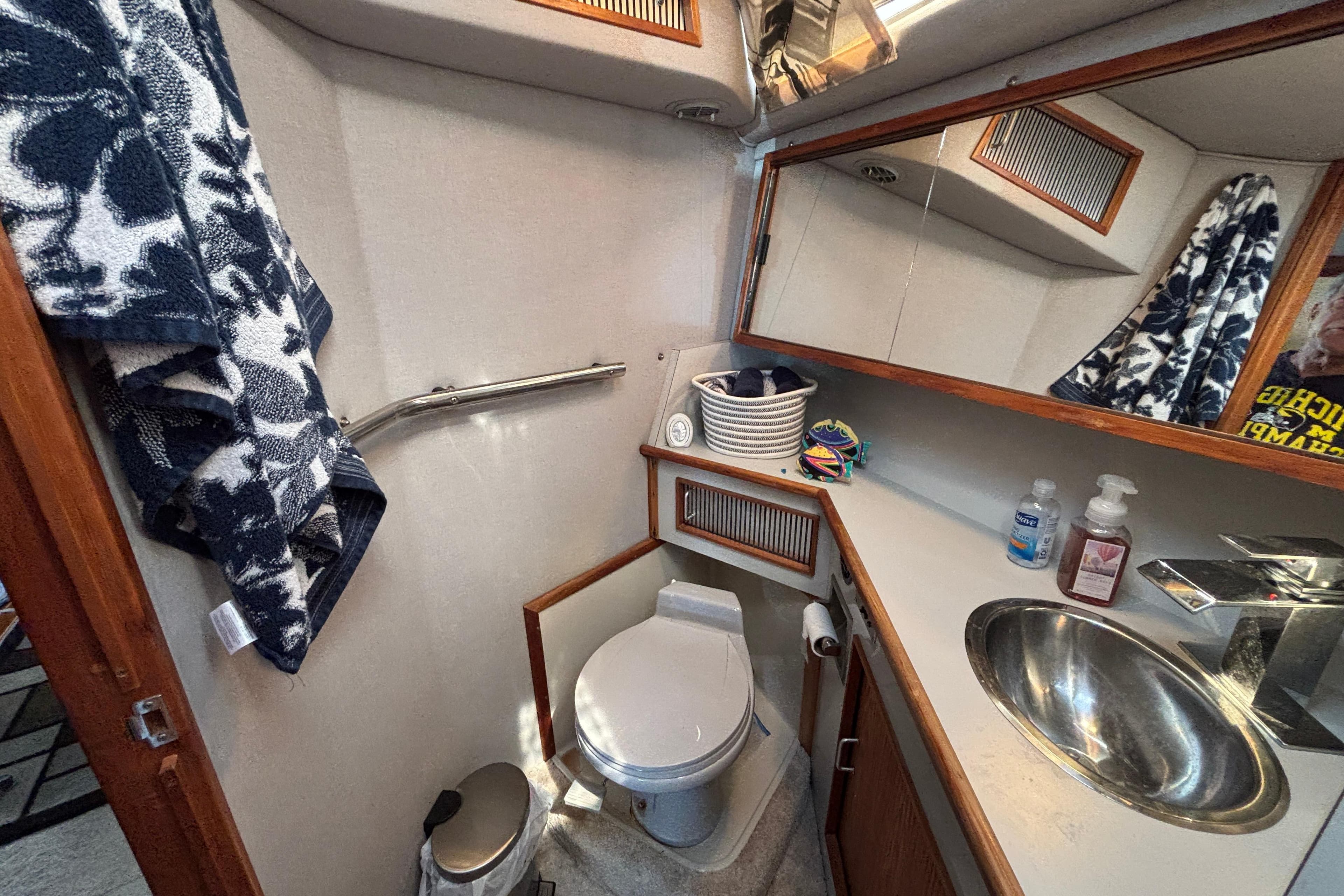 1989 Sea Ray 400 Express Cruiser bathroom with sink, toilet, and storage.