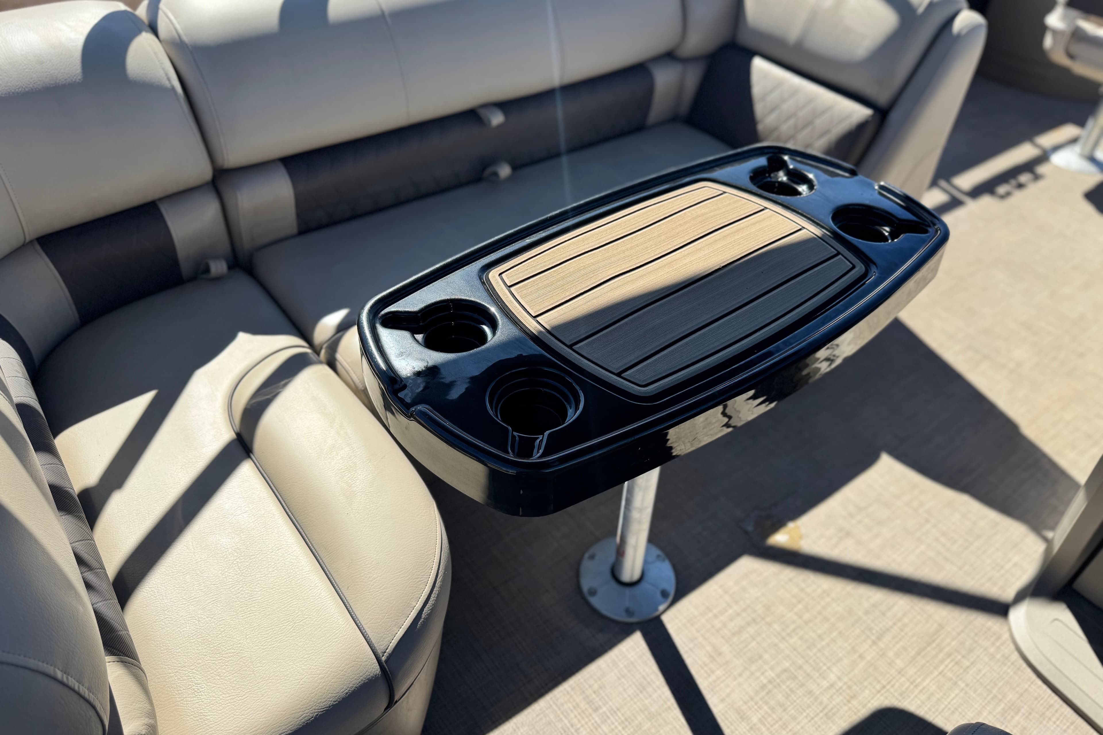 2024 Sun Tracker Fishin' Barge 20 DLX interior with table and cup holders.