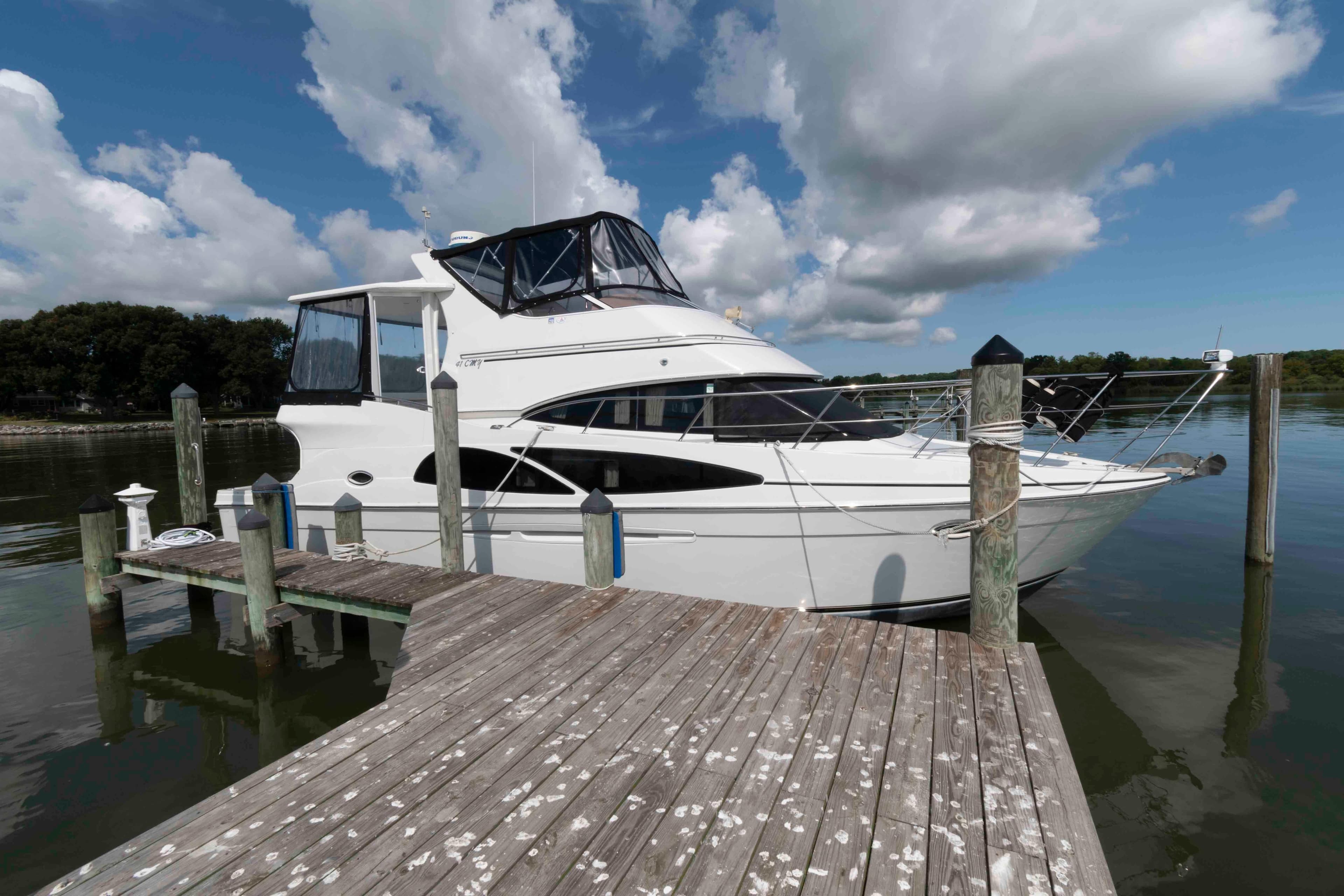 2005 Carver 41 Cockpit Motor Yacht docked on a sunny day with cloudy sky.
