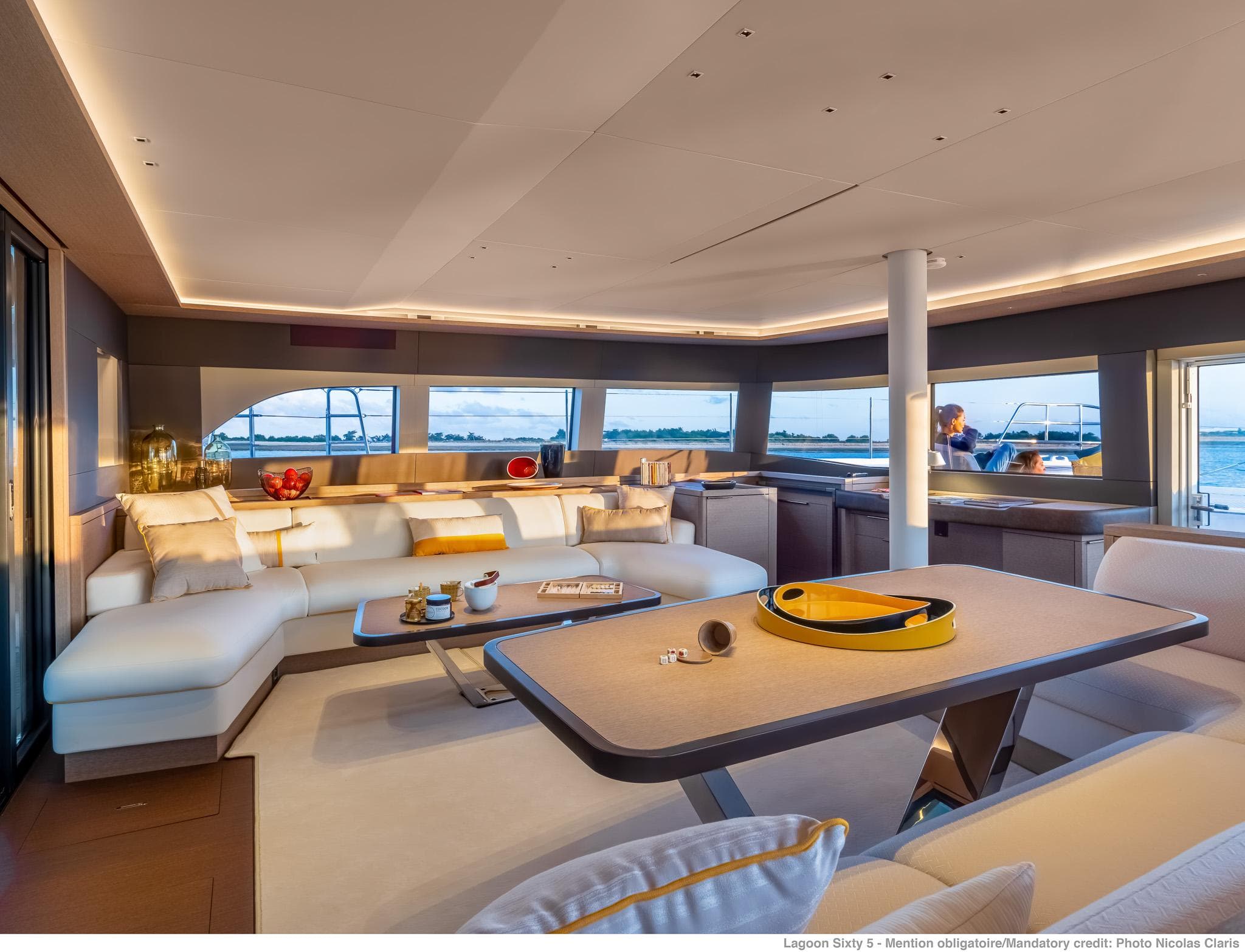 Luxurious interior of 2025 Lagoon SIXTY 5 yacht with modern furnishings and panoramic windows.