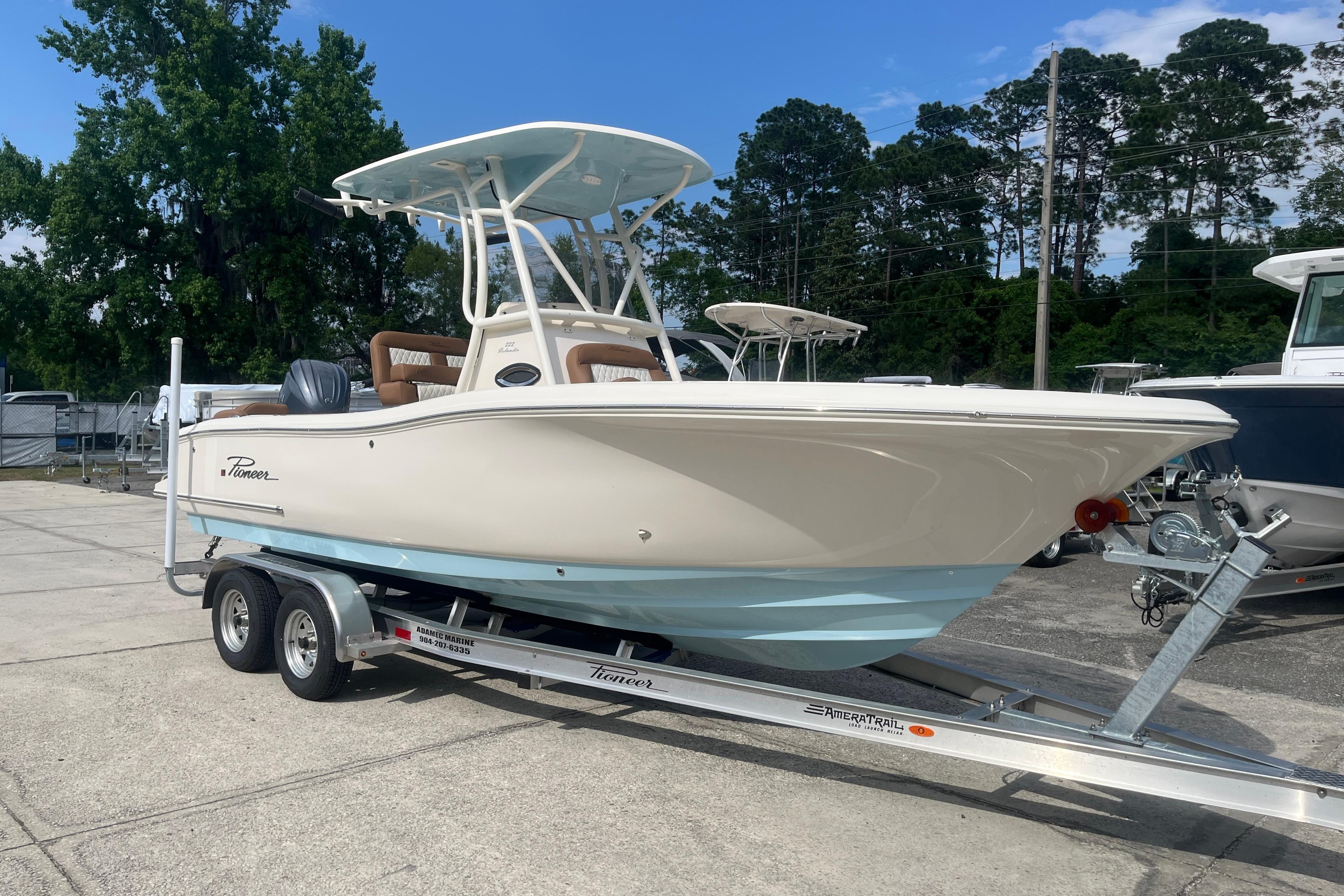 2026 Pioneer 222 Islander boat on trailer, parked outdoors with trees in background.
