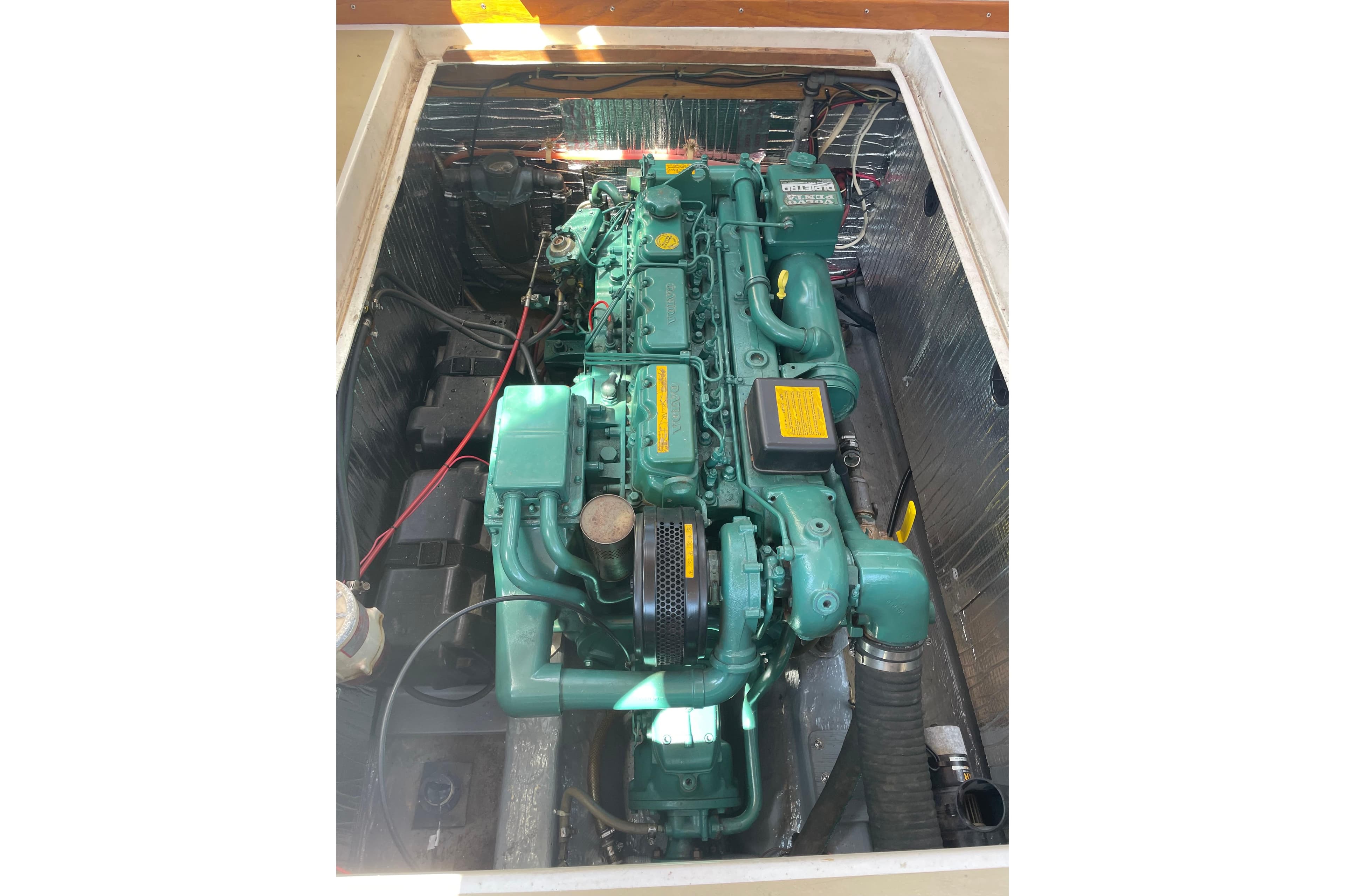 Engine compartment of a 1988 Cape Dory Hardtop boat, showcasing a green marine engine.