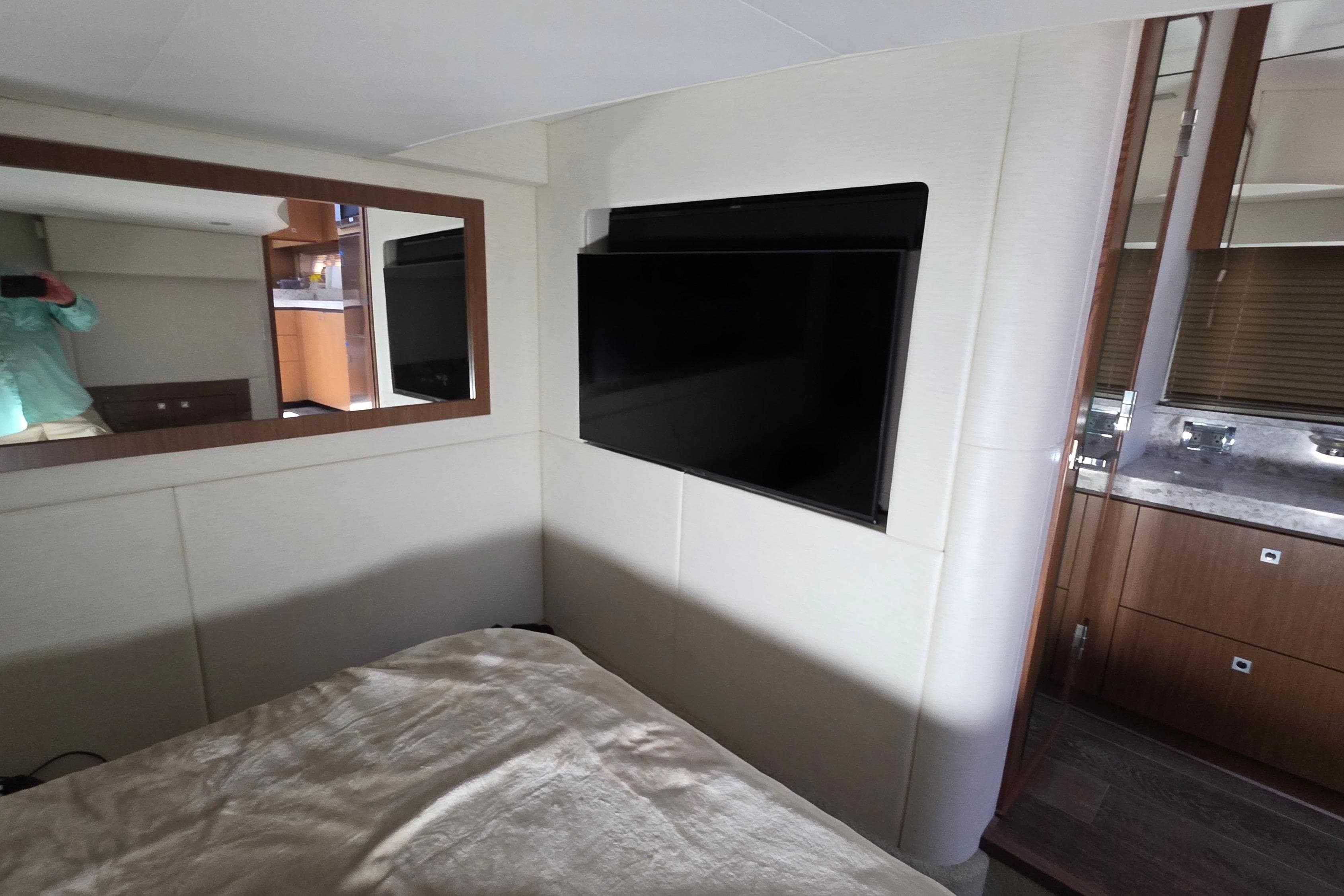 Interior of 2018 Sea Ray Sundancer 510 yacht with TV and mirror in cabin.