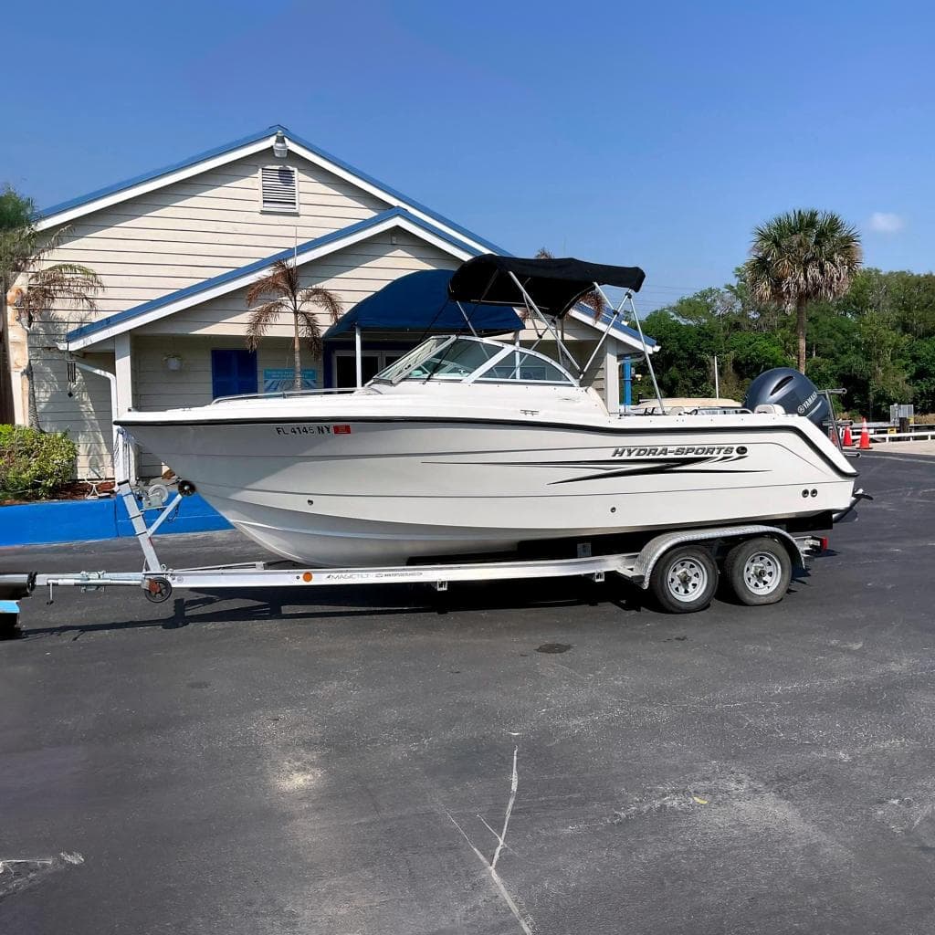 2009 Hydra-Sports Lightning 202 DC boat on trailer in front of building.