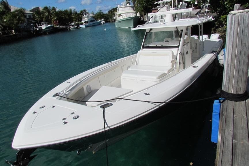 2016 Everglades 435 Center Console boat docked in a scenic marina.