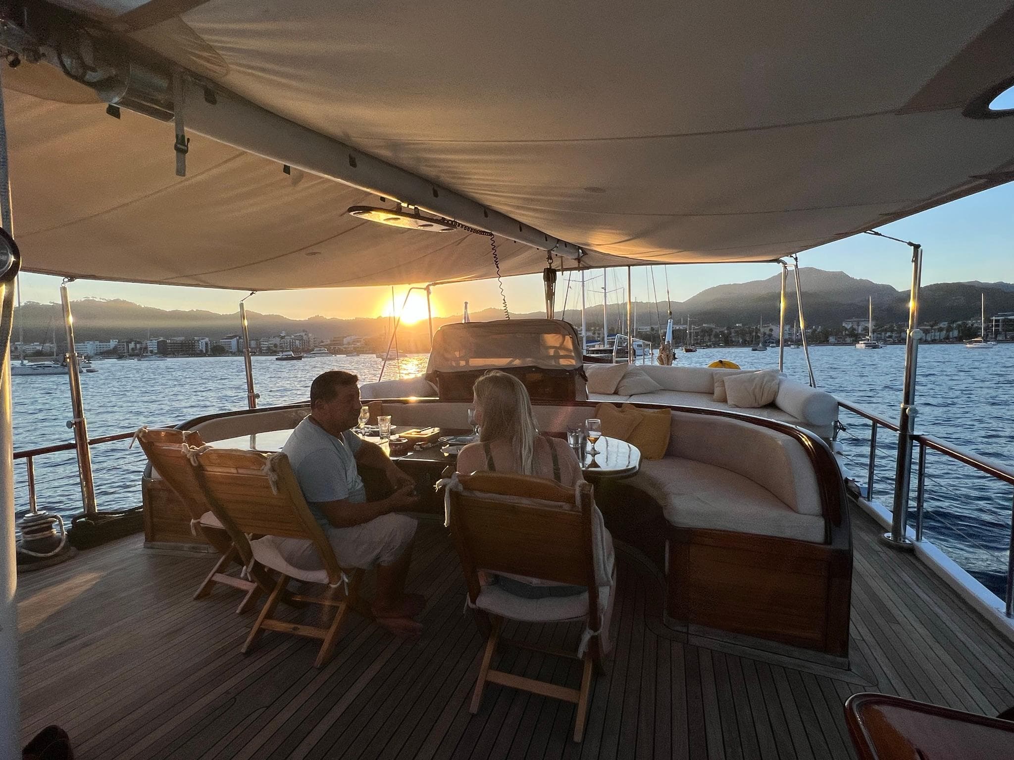 Couple enjoying sunset on 2006 Custom Gulet Ketch yacht deck.