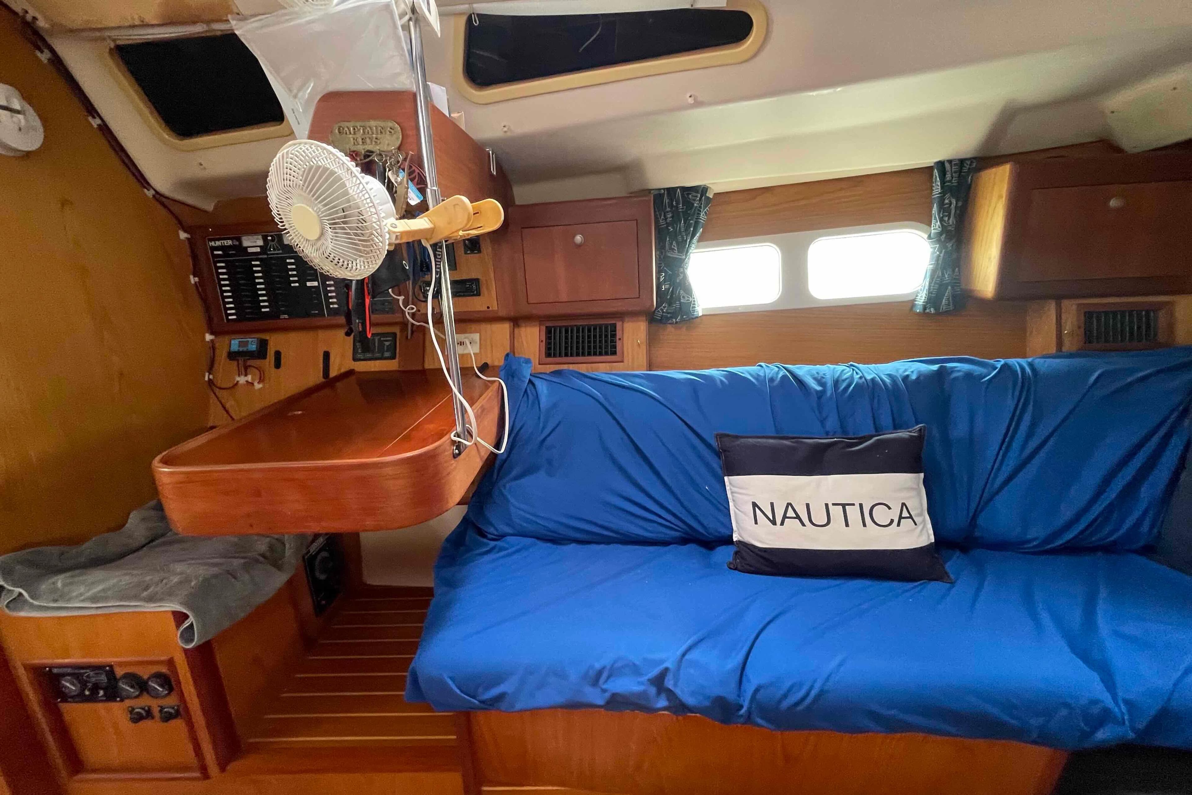 Interior of a 2000 Hunter 410 sailboat with blue seating and nautical decor.