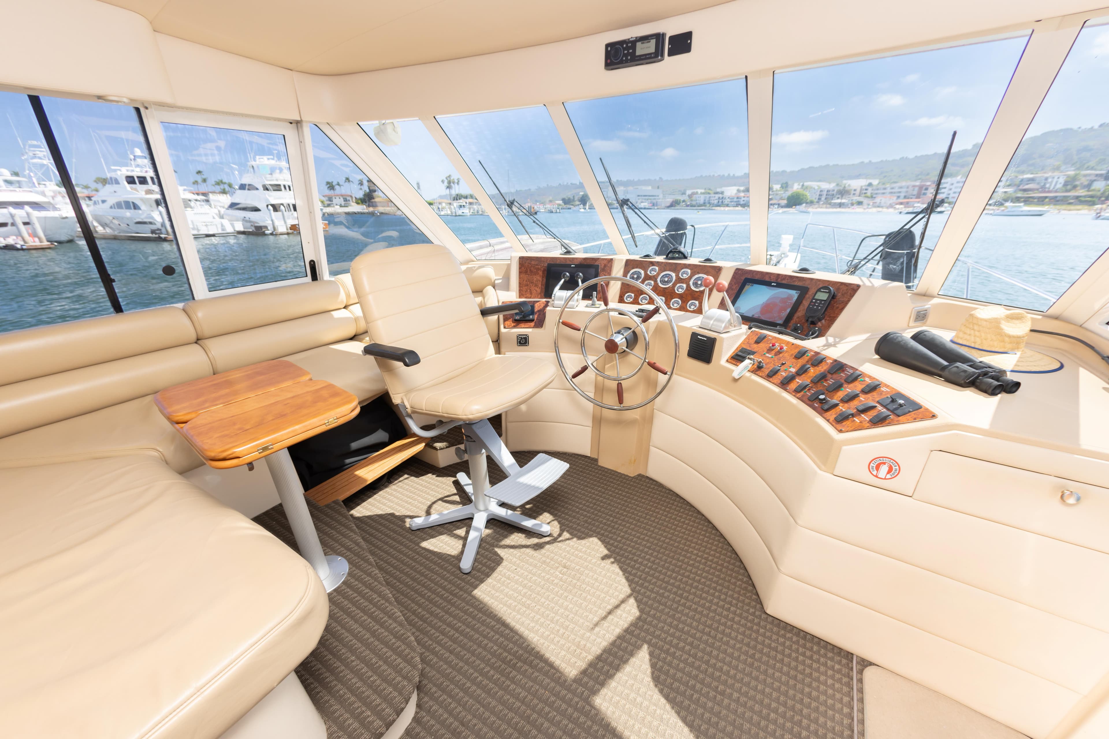 Luxurious 2004 Meridian 490 Pilothouse interior with helm, leather seating, and panoramic windows.
