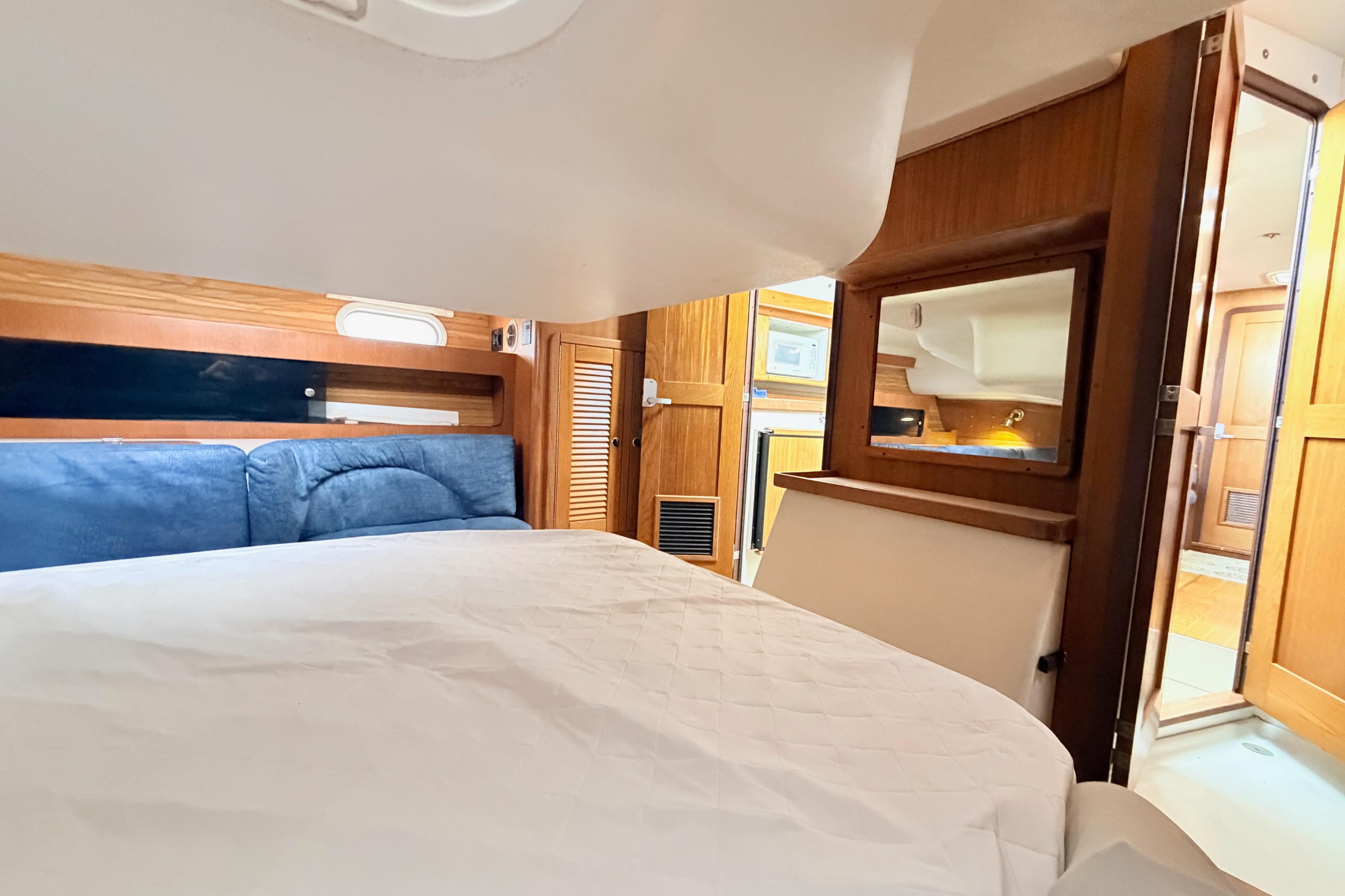 Interior cabin of a 2001 Catalina 380 sailboat with cozy bed and wooden accents.