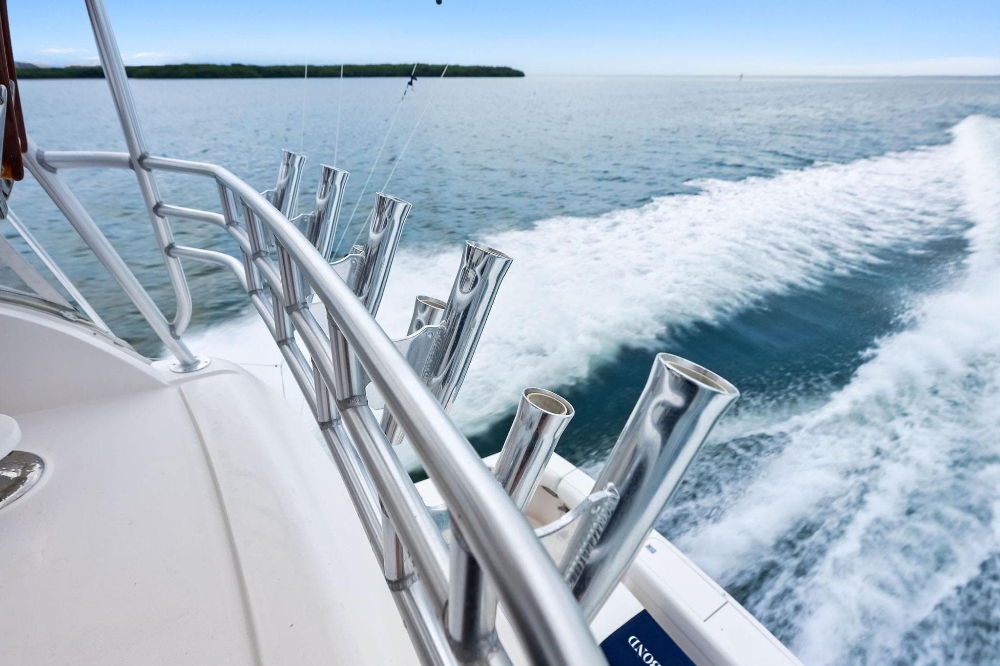 2006 Bertram 39 Convertible yacht cruising on open water, featuring sleek metal railings.