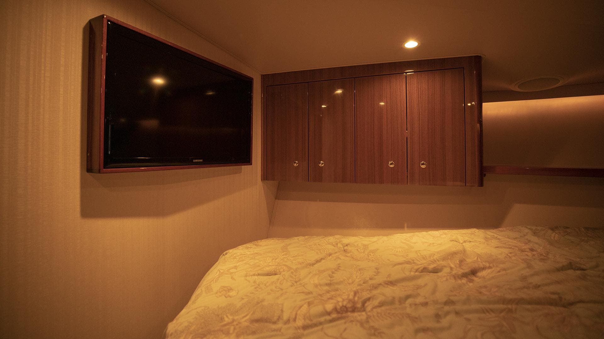 Luxurious cabin interior of 2007 Viking 45 Convertible yacht with TV and wooden cabinets.