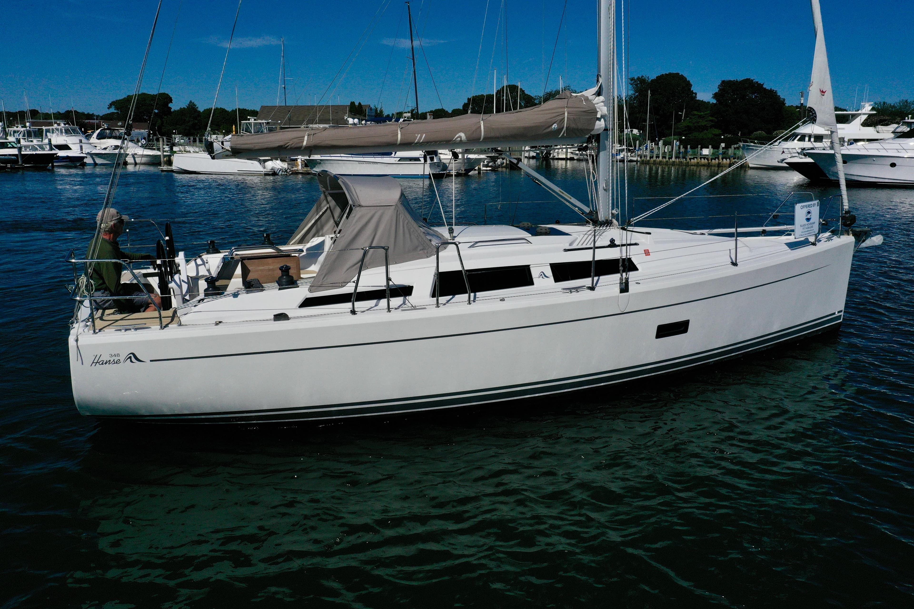 2018 Hanse 348 sailboat docked in a marina under clear blue skies.