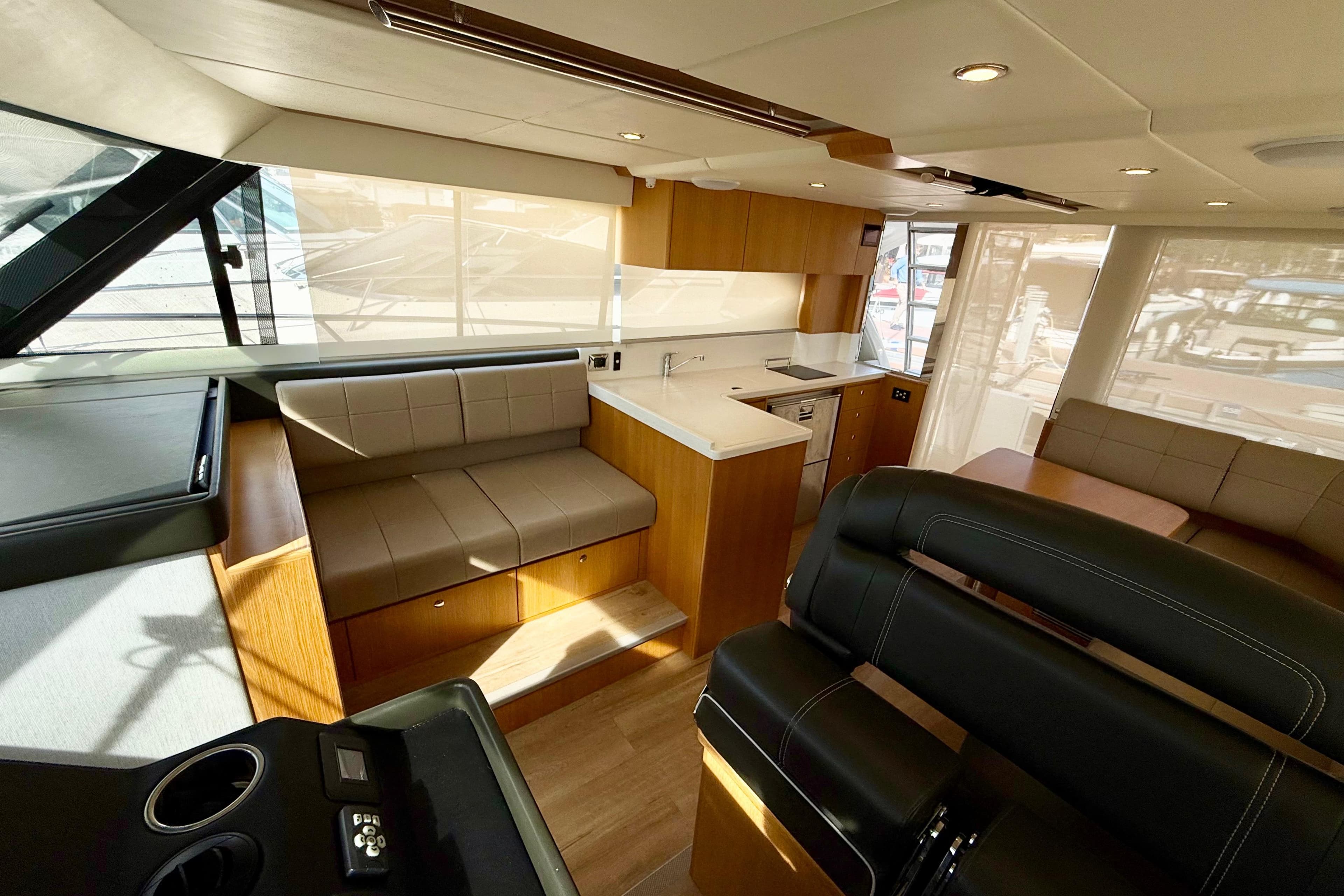 Luxurious interior of 2019 Riviera 39 Sports Motor Yacht with modern seating and kitchen.