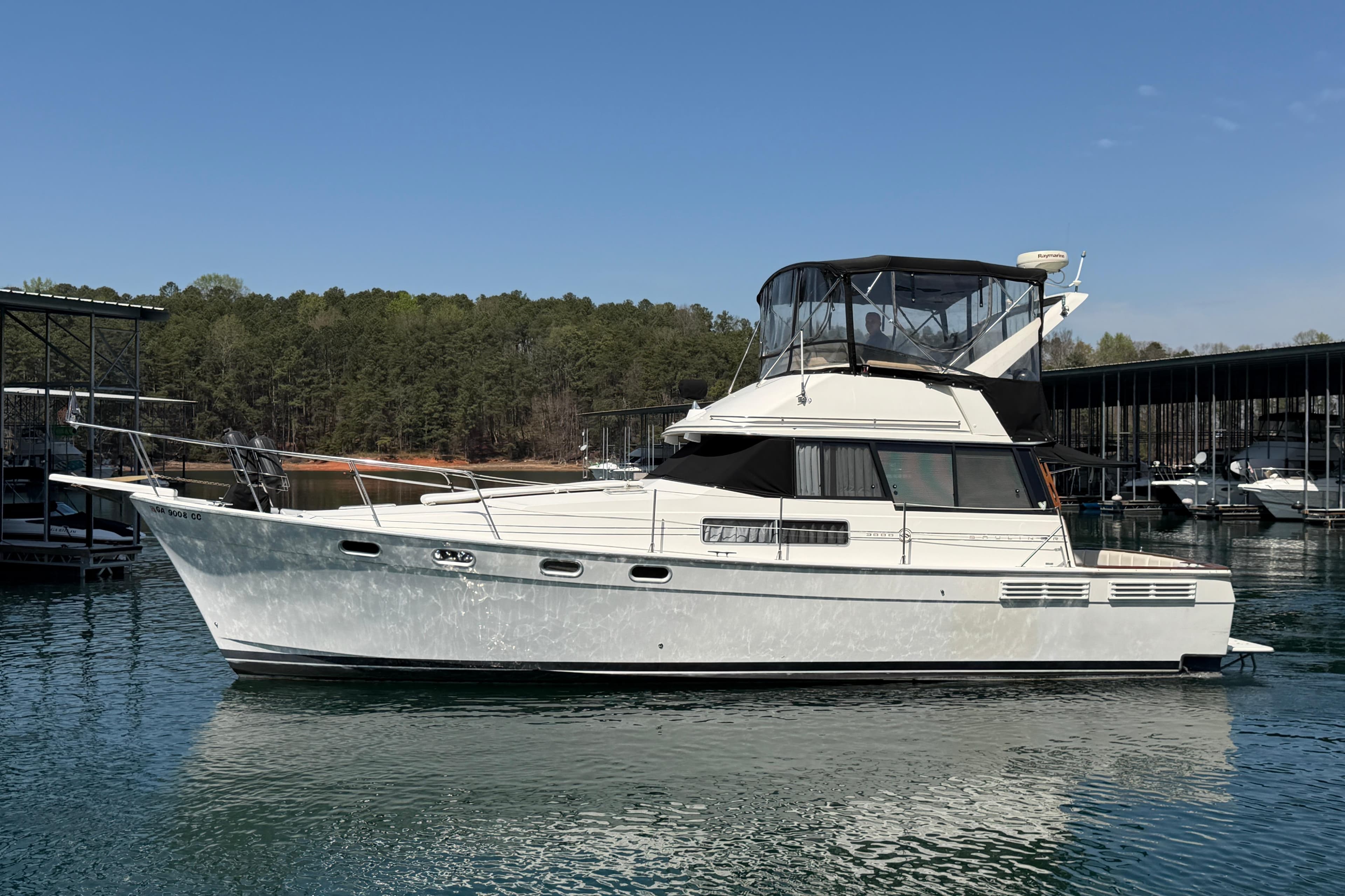 1994 Bayliner 3888 MY Sedan yacht on calm water, surrounded by trees and docks.