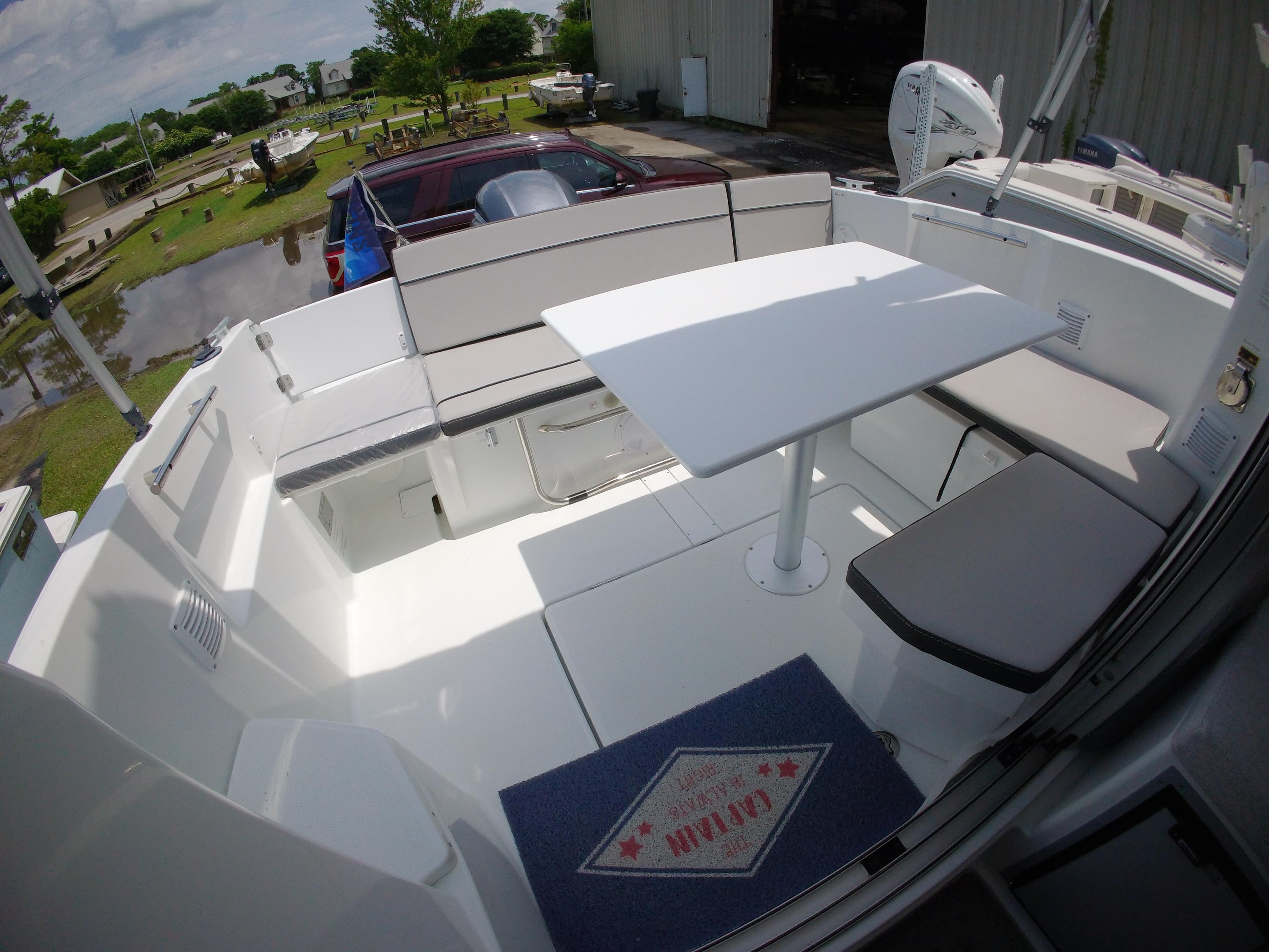 2022 Jeanneau NC 695 Series 2 boat deck with seating and table, outdoor setting.