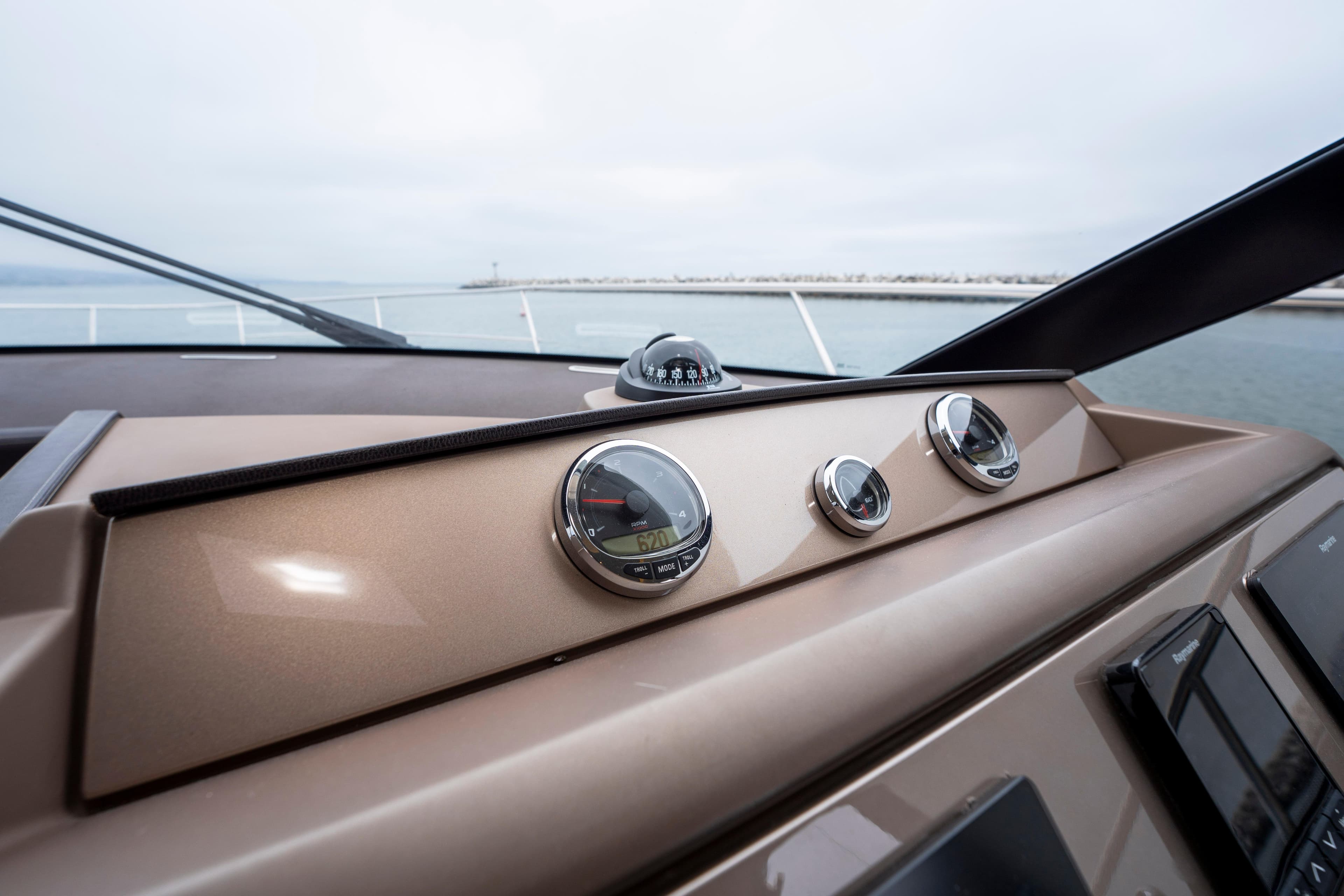 Control panel of 2018 Prestige 560 yacht with gauges and compass.