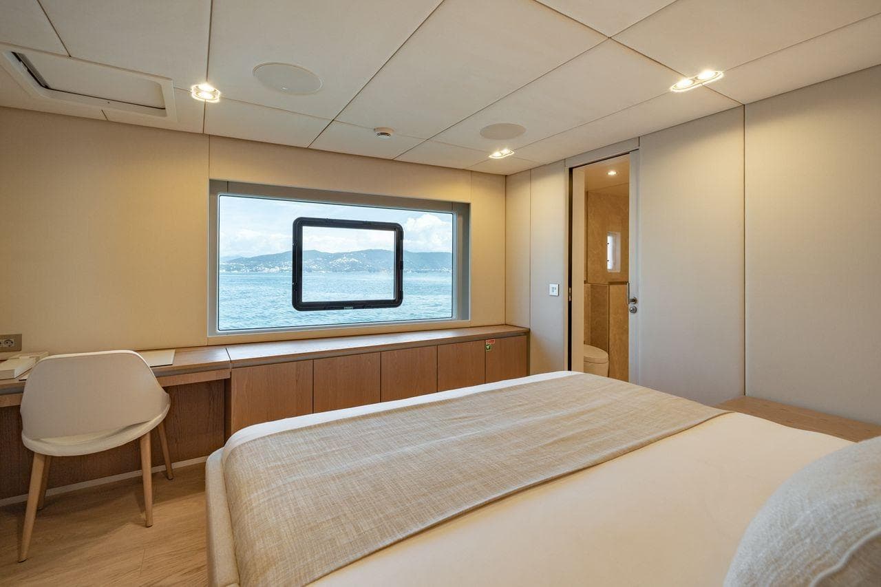 Luxurious Sunreef 100 Power 2025 yacht bedroom with ocean view and modern interior design.