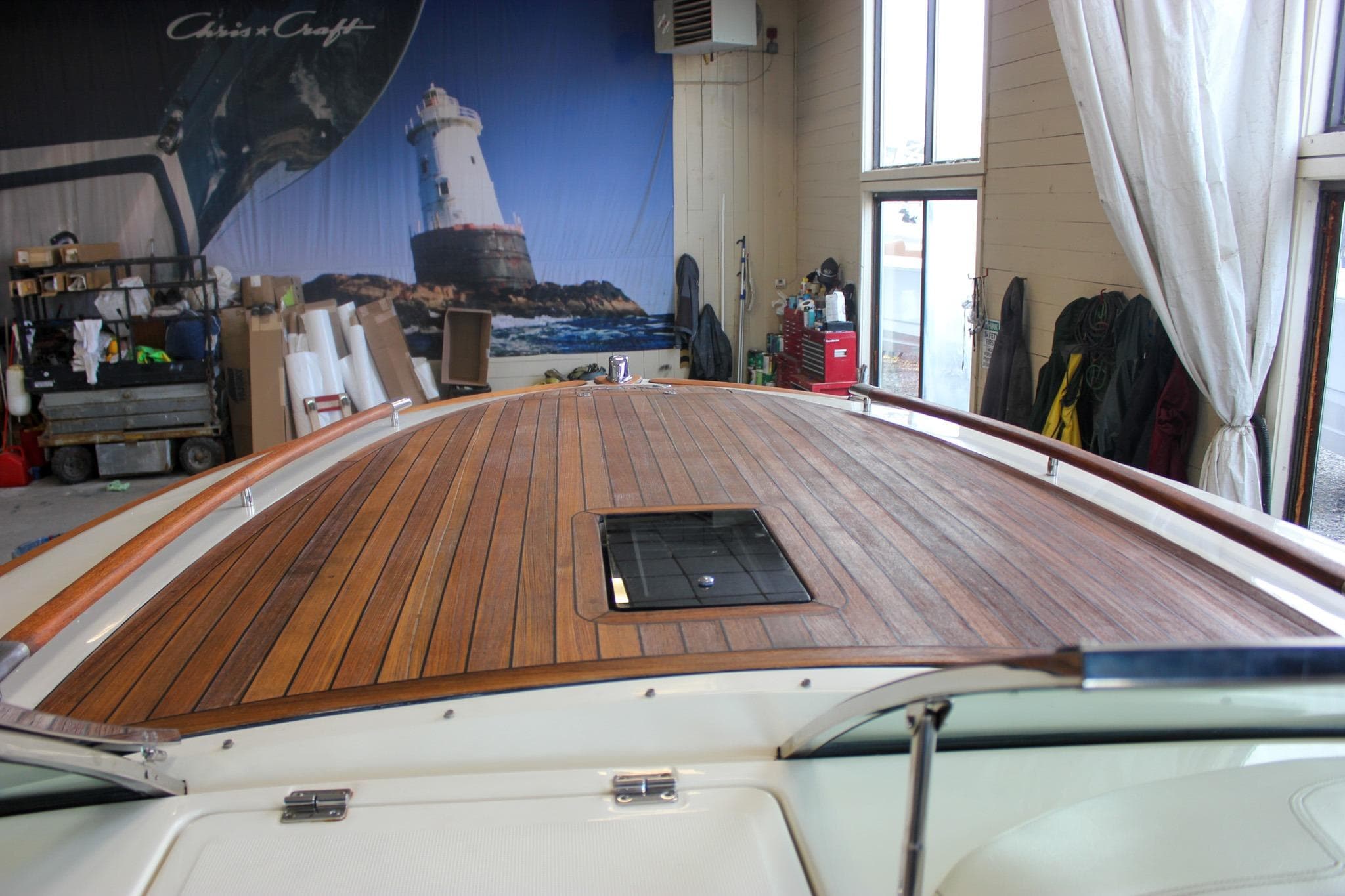 2011 Chris-Craft Corsair 28 boat with wooden deck in a workshop setting.