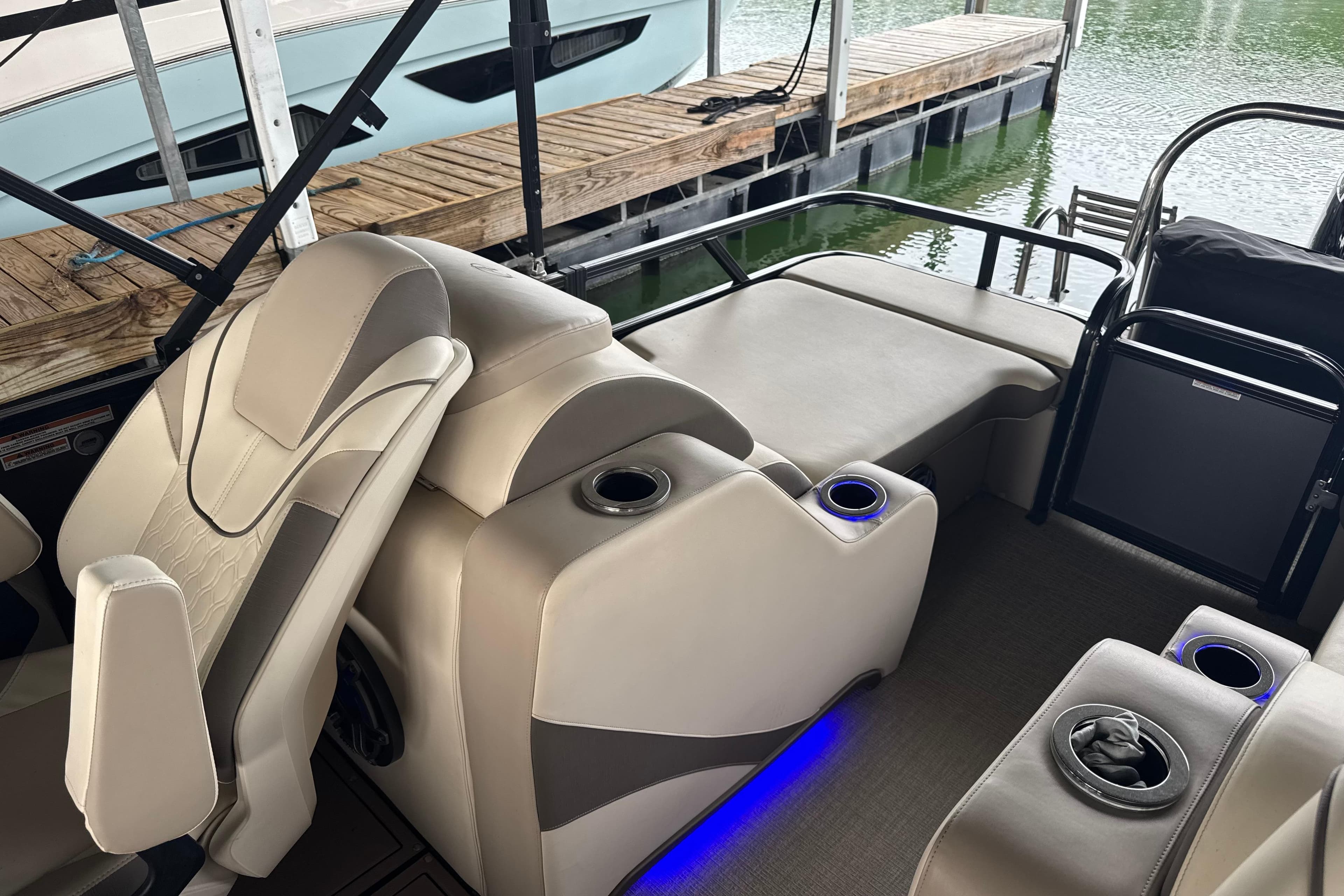 2023 Avalon LSZ 2585 RL pontoon boat interior with beige seating and cup holders.
