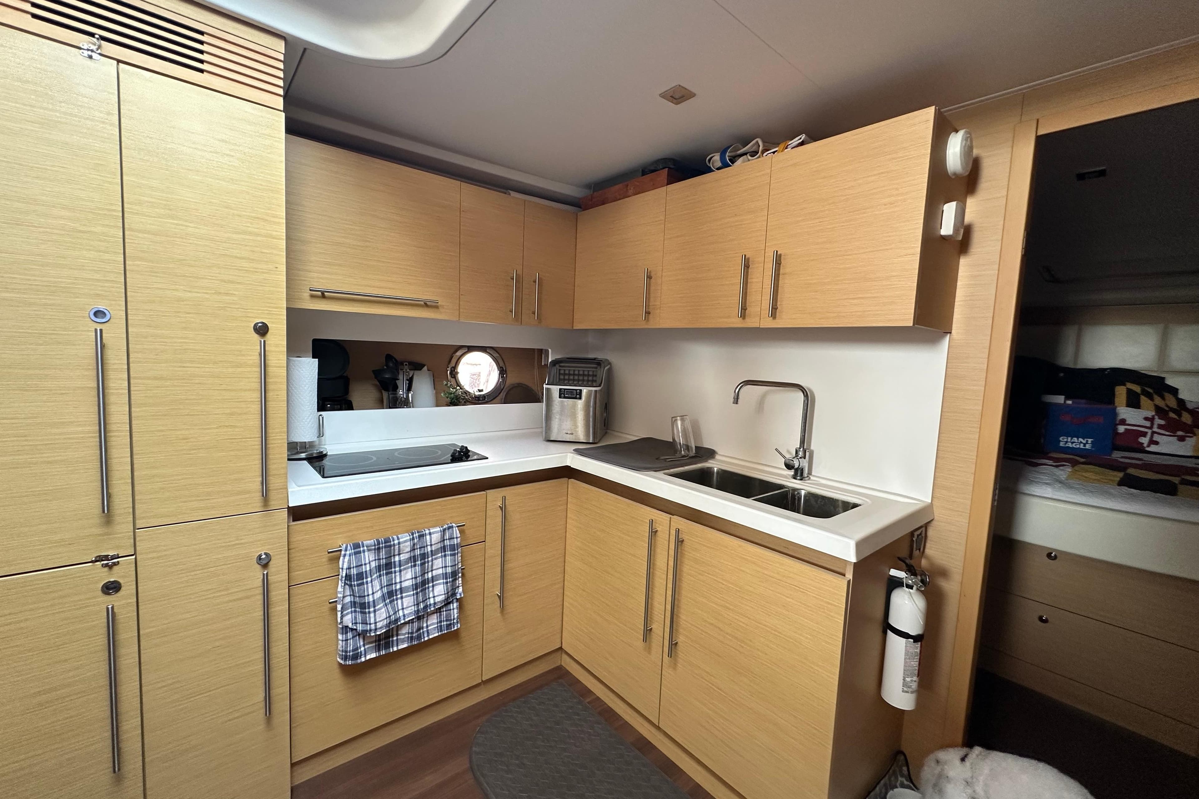 Modern kitchen interior of 2011 Beneteau Monte Carlo 47 Fly yacht, featuring wood cabinetry and dual sinks.