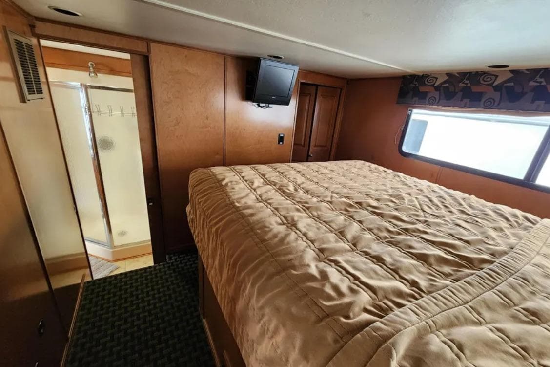 Luxurious bedroom interior of 2008 Sumerset Blue Moon Trip houseboat with cozy bedding.