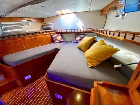 Luxurious cabin interior of 1981 Joyce 16.5 yacht with cozy bedding and wooden accents.