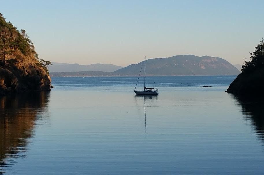 Sailboat on calm water with scenic mountain backdrop, C&C 33, 1986 model.