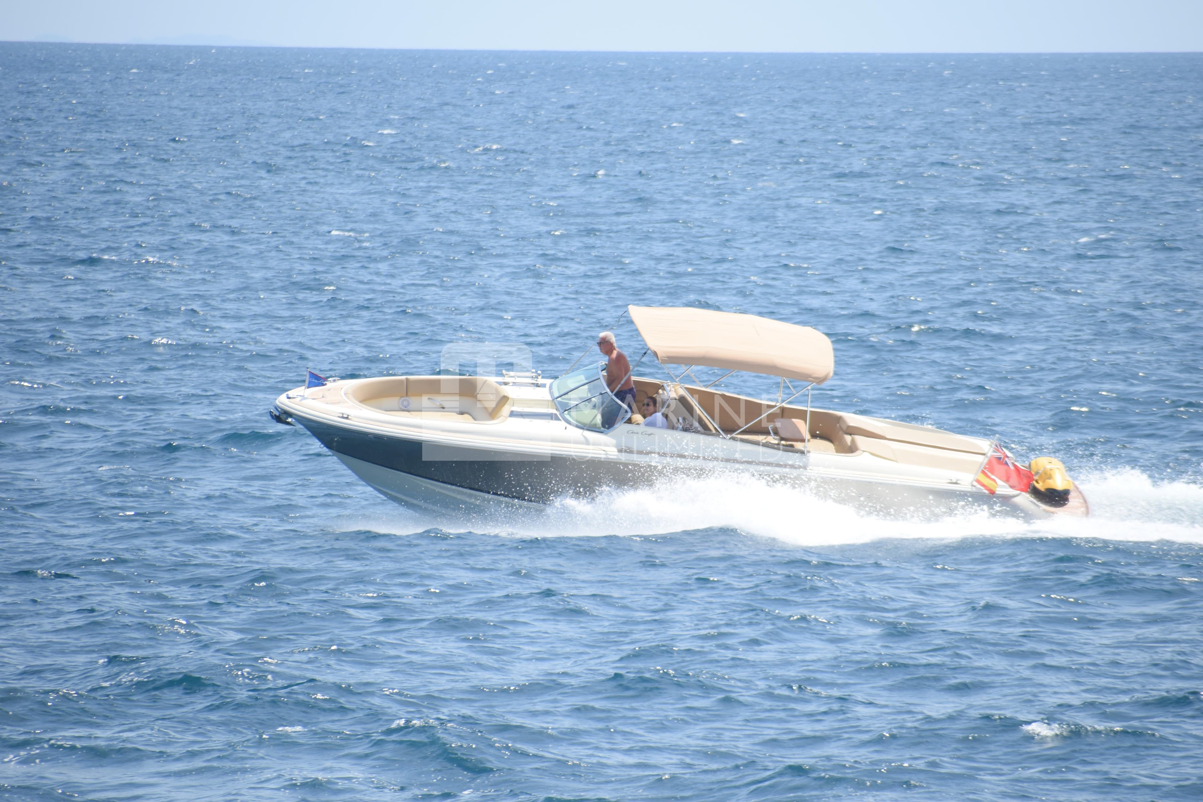 2015 Chris-Craft Launch 32 boat cruising on open sea with canopy.