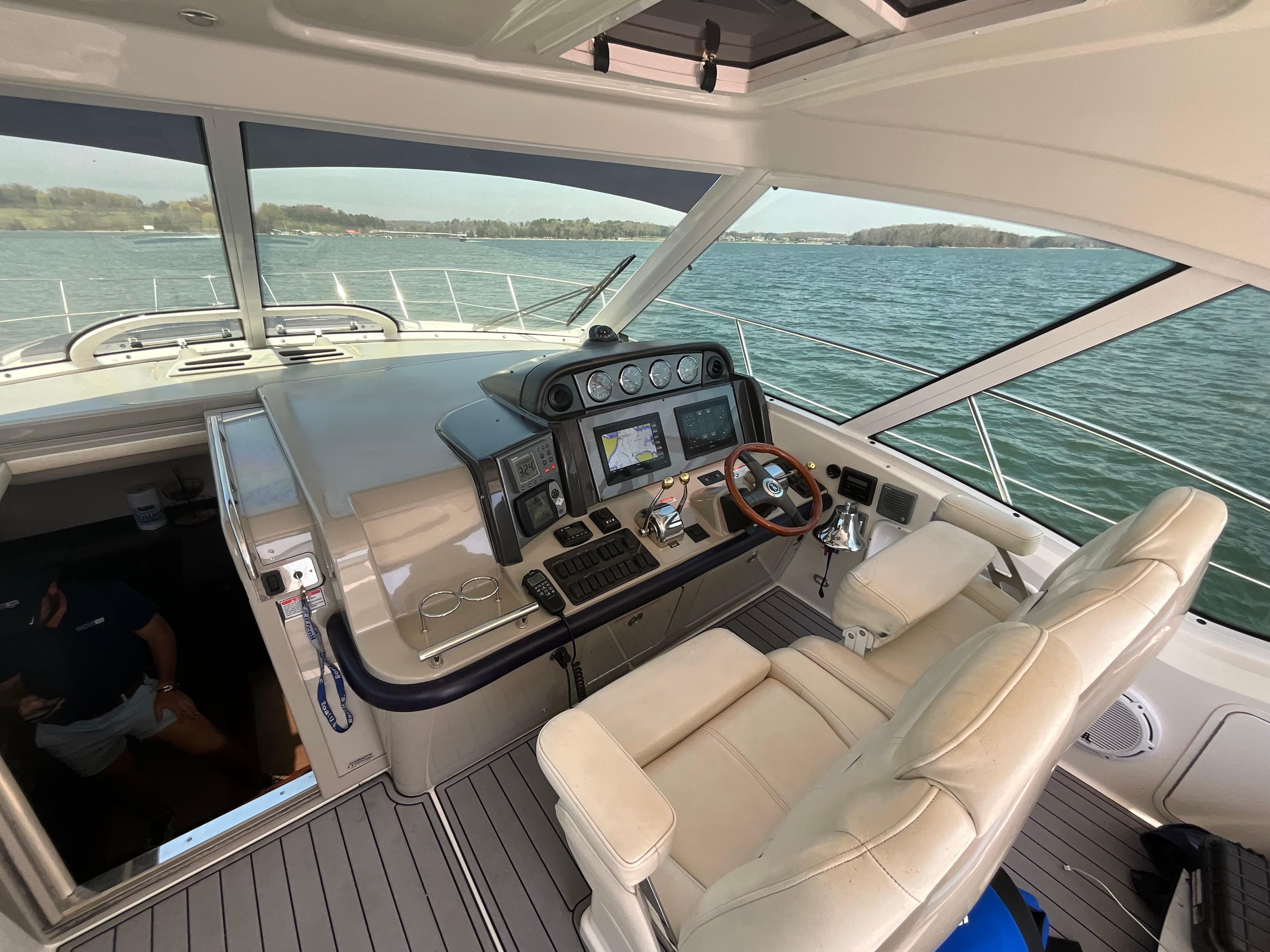 2006 Sea Ray 48 Sundancer helm with modern controls, overlooking serene waters.