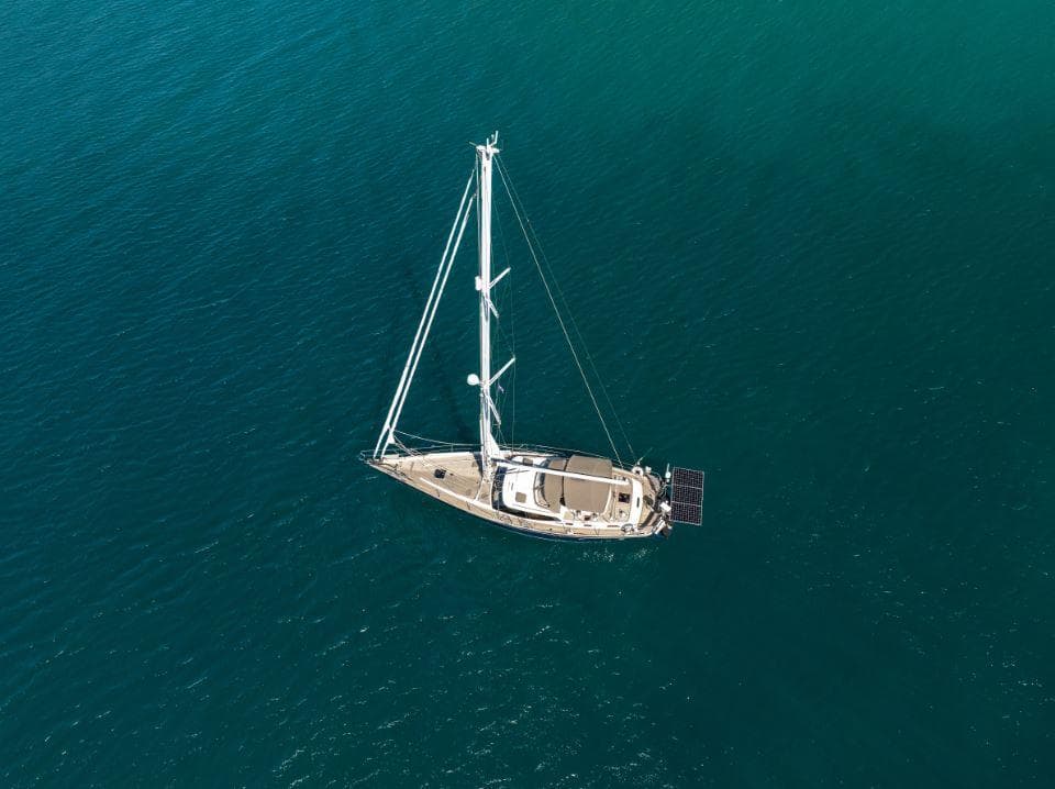 Aerial view of 2008 Discovery 55 sailboat on calm blue water.