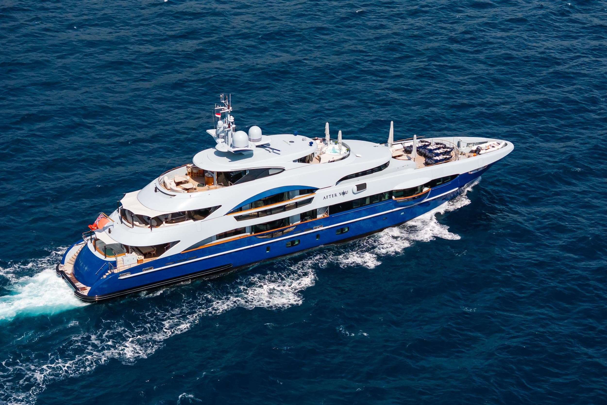 Luxurious 2011 Heesen 55m yacht cruising on open sea, aerial view.